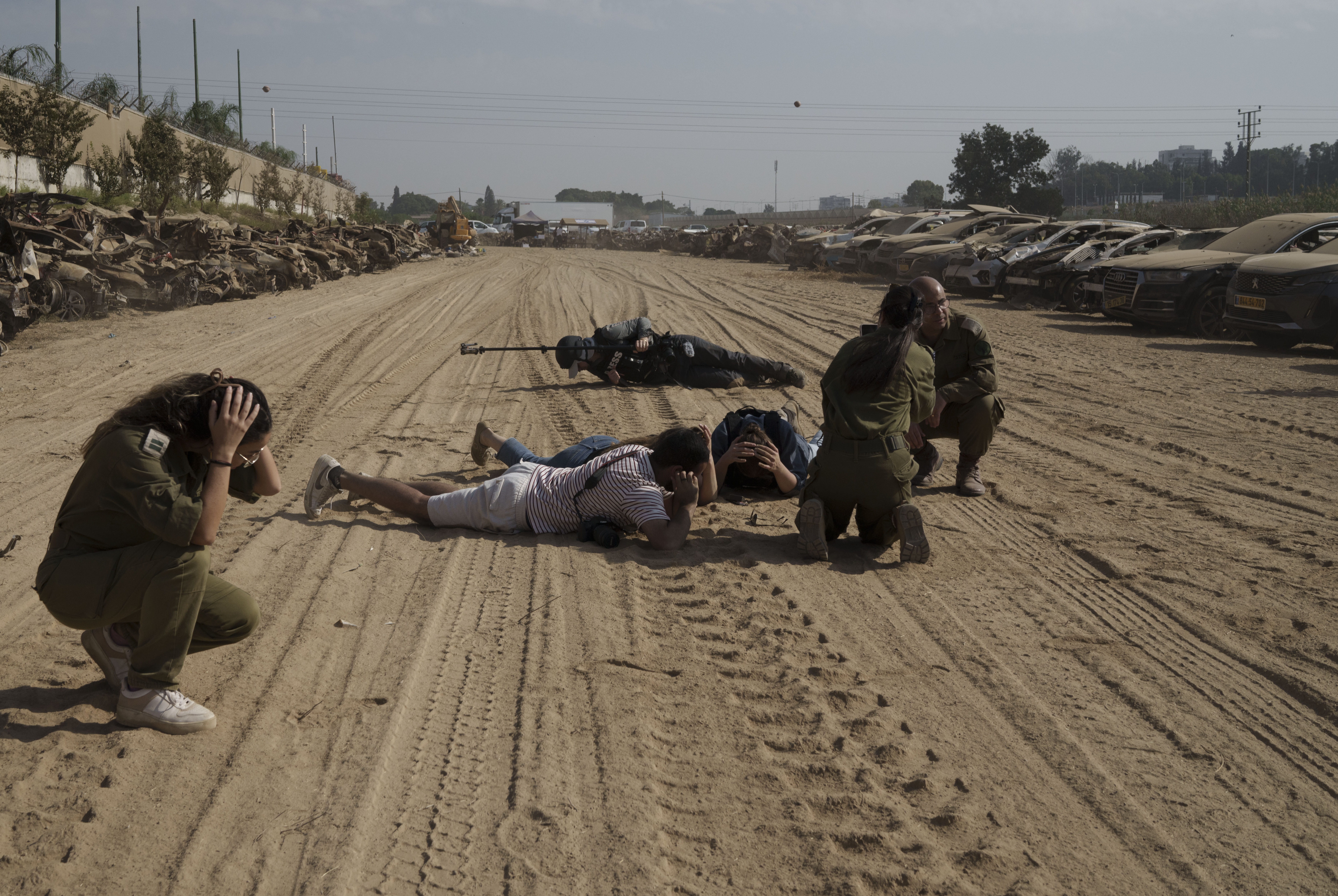 Sun., Nov. 5: Israeli soldiers and journalists take cover as a siren warns of incoming rockets fired from the Gaza Strip in an area where hundreds of destroyed vehicles are kept that were damaged in the bloody Oct. 7 cross-border attack by Hamas militants, in which at least 1,200 people were killed and 240 others were taken hostage, outside the town of Netivot, southern Israel.