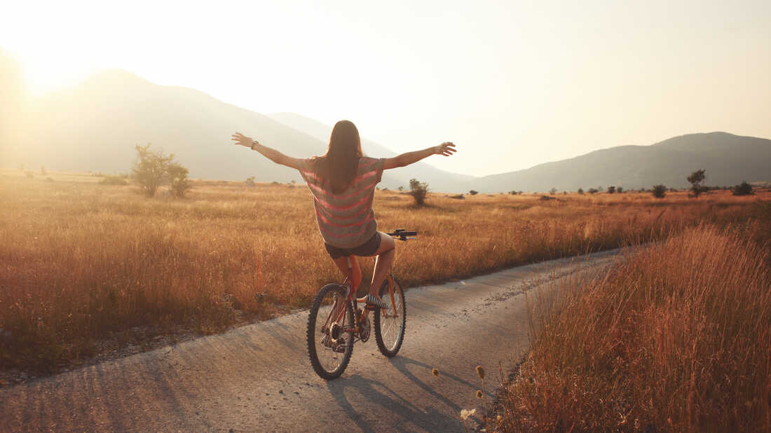 vintage toned young brunette on a bicycle, lit by the Autumn sunset.