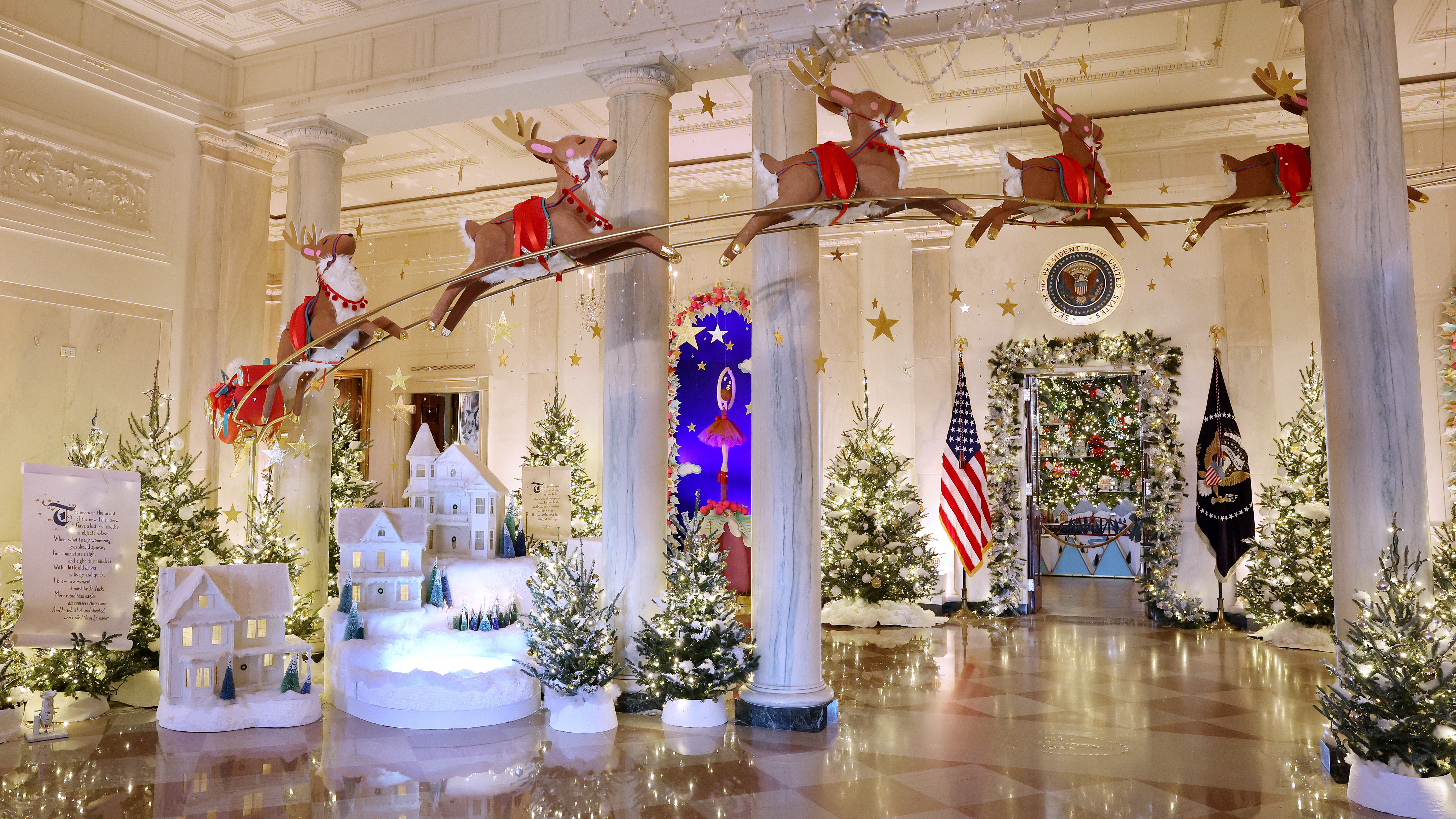 Santa Claus in his sleigh and a team of reindeer fly through the columns of the Entrance Hall of the White House. The theme for this year's White House decorations is "Magic, Wonder and Joy."