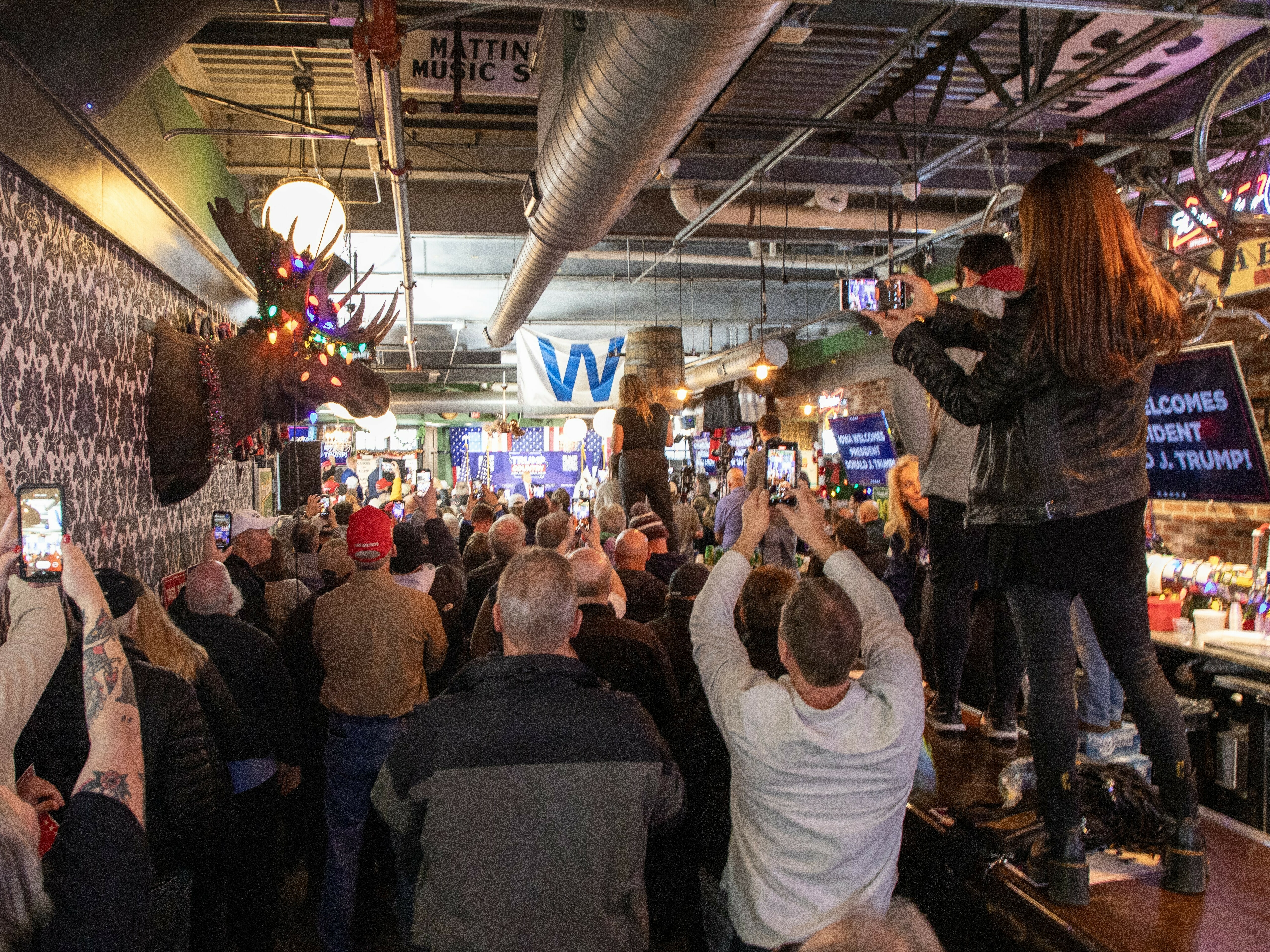 Trump and DeSantis display different campaign styles in competing visits to Iowa 1 Supporters of former President Donald Trump stand on the bar at Whiskey River in Ankeny, Iowa to get a look at him as he campaigns for the Republican presidential nomination in 2024.