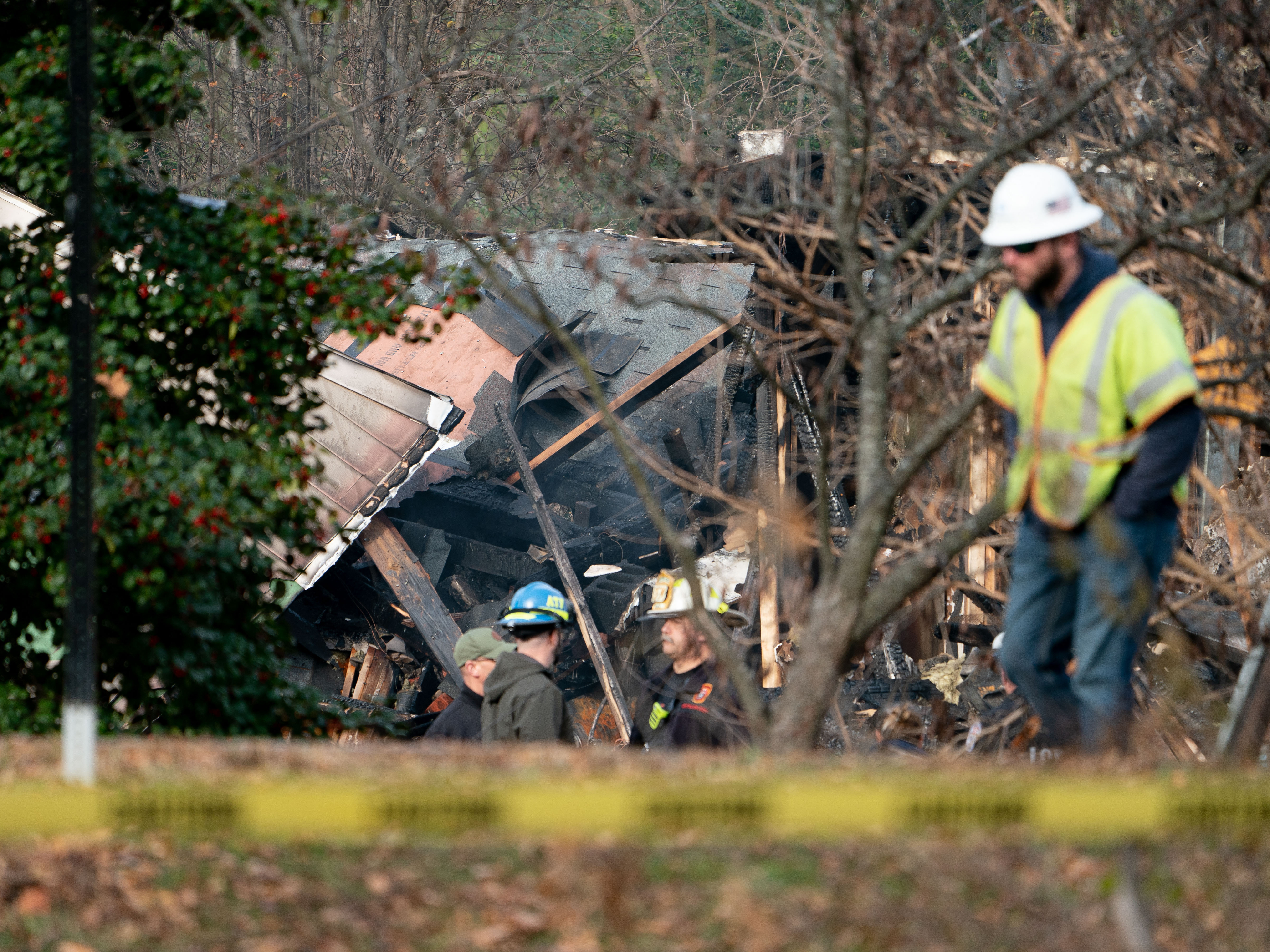 Workers on Tuesday examine the home that exploded in Arlington, Va., on Monday night. (AFP via Getty Images)