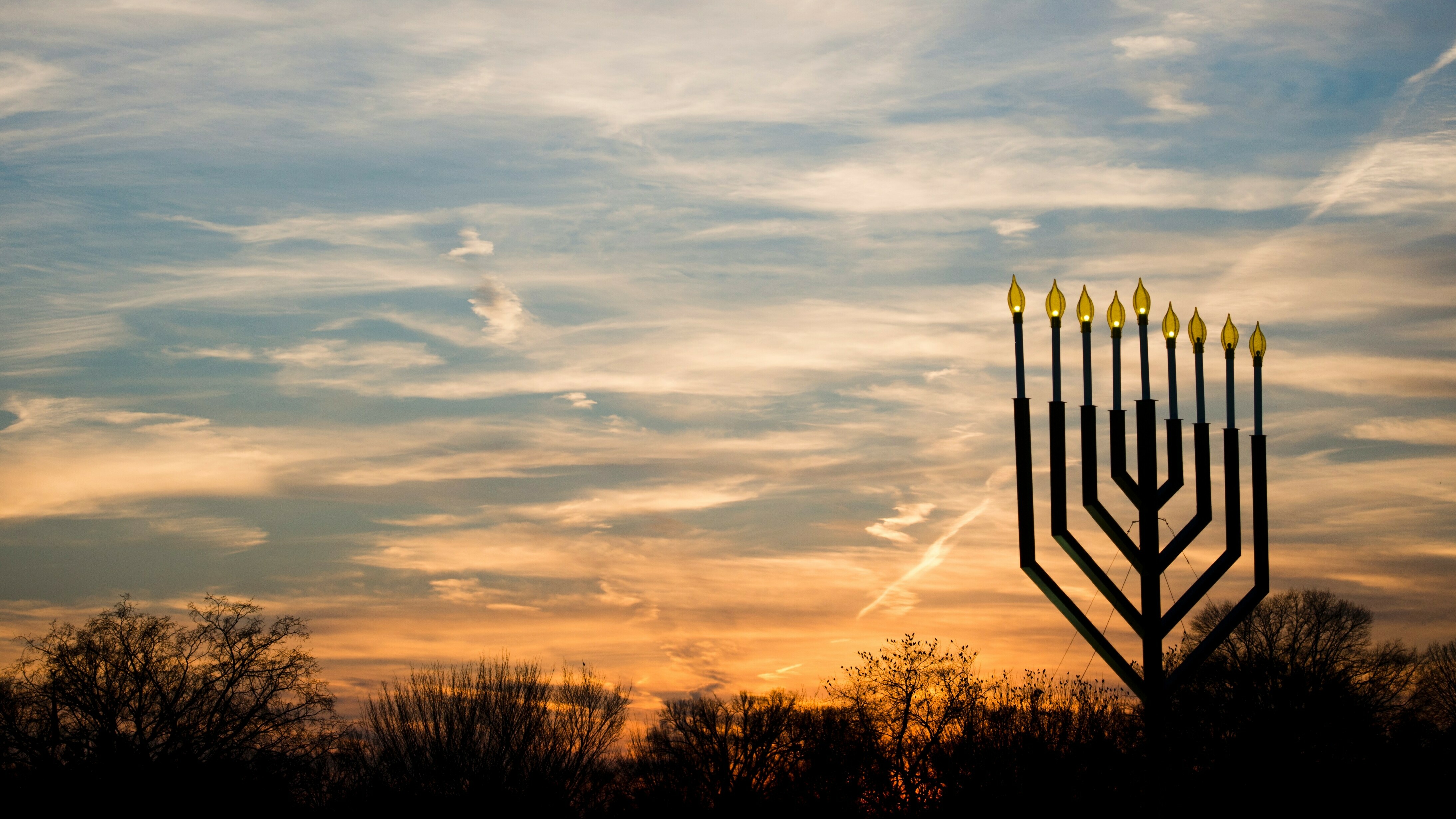 The National Menorah, part of the Jewish holiday of Hanukkah, is silhouetted against the setting sun in Washington, D.C.