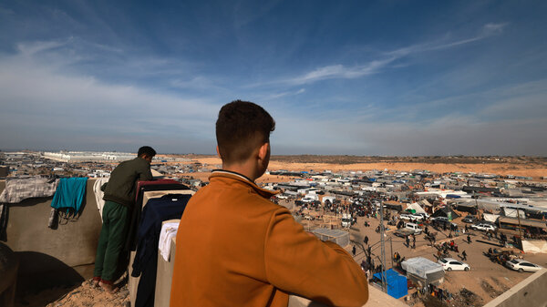People look out from a rooftop last week as displaced Palestinians who fled Khan Younis in the southern Gaza Strip set up camp in Rafah, farther south, near Gaza's border with Egypt.
