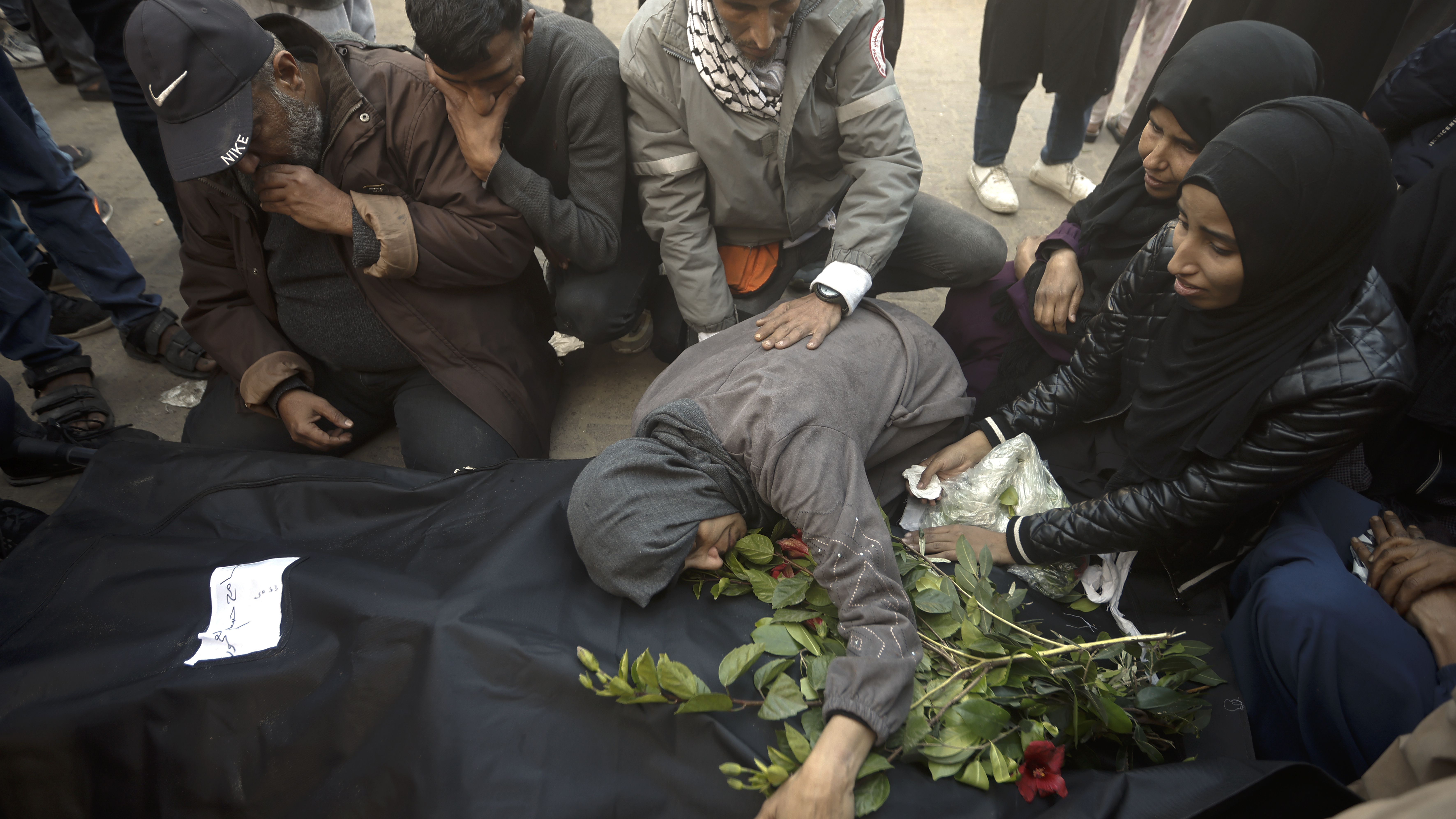 Palestinians mourn relatives killed in the Israeli bombardment of the Gaza Strip outside a morgue in Khan Younis on Sunday, Dec. 24, 2023.