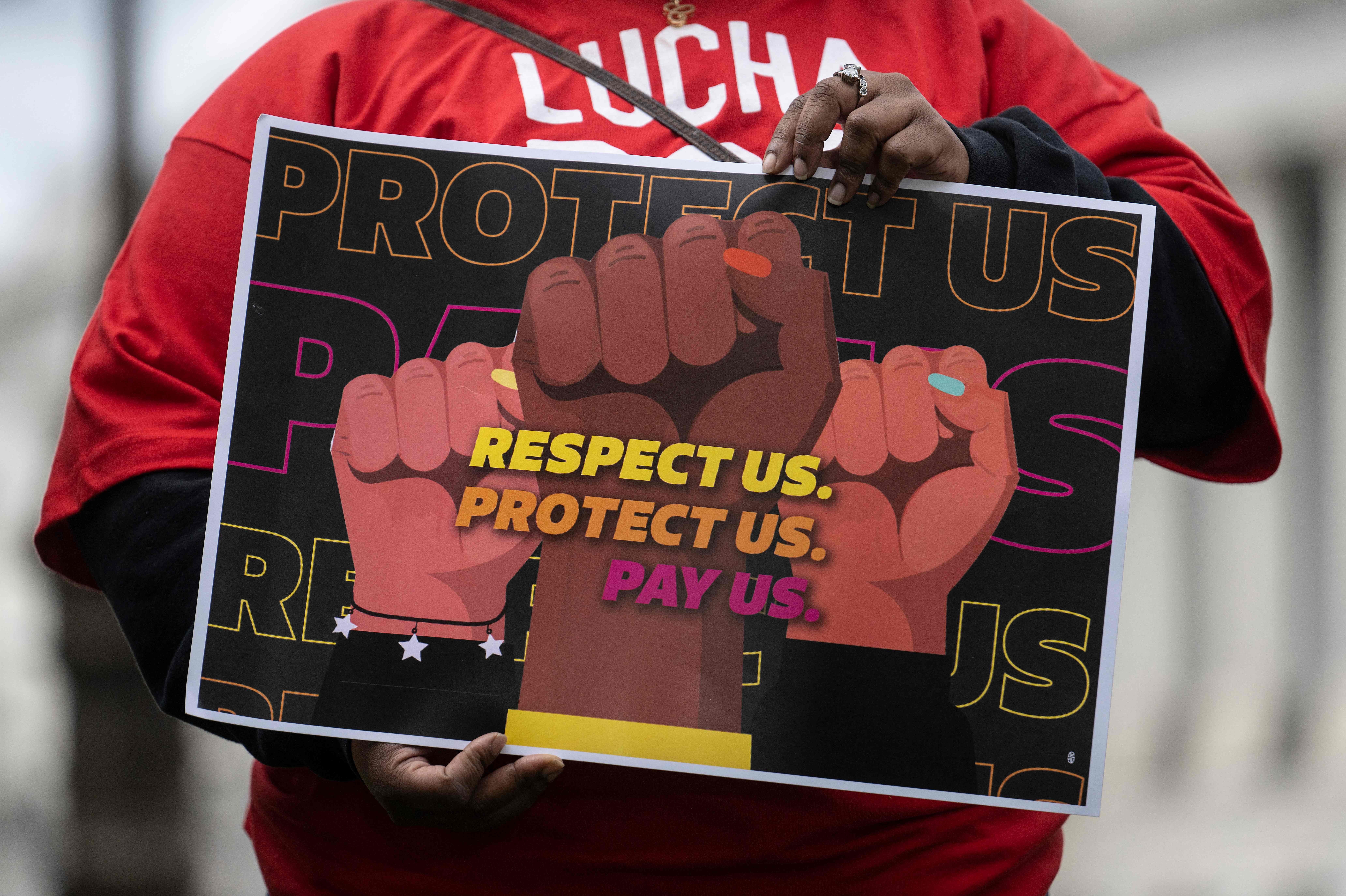 A person holds a sign at a rally to raise the federal minimum wage, on Capitol Hill in Washington, D.C., on May 4. (AFP via Getty Images)