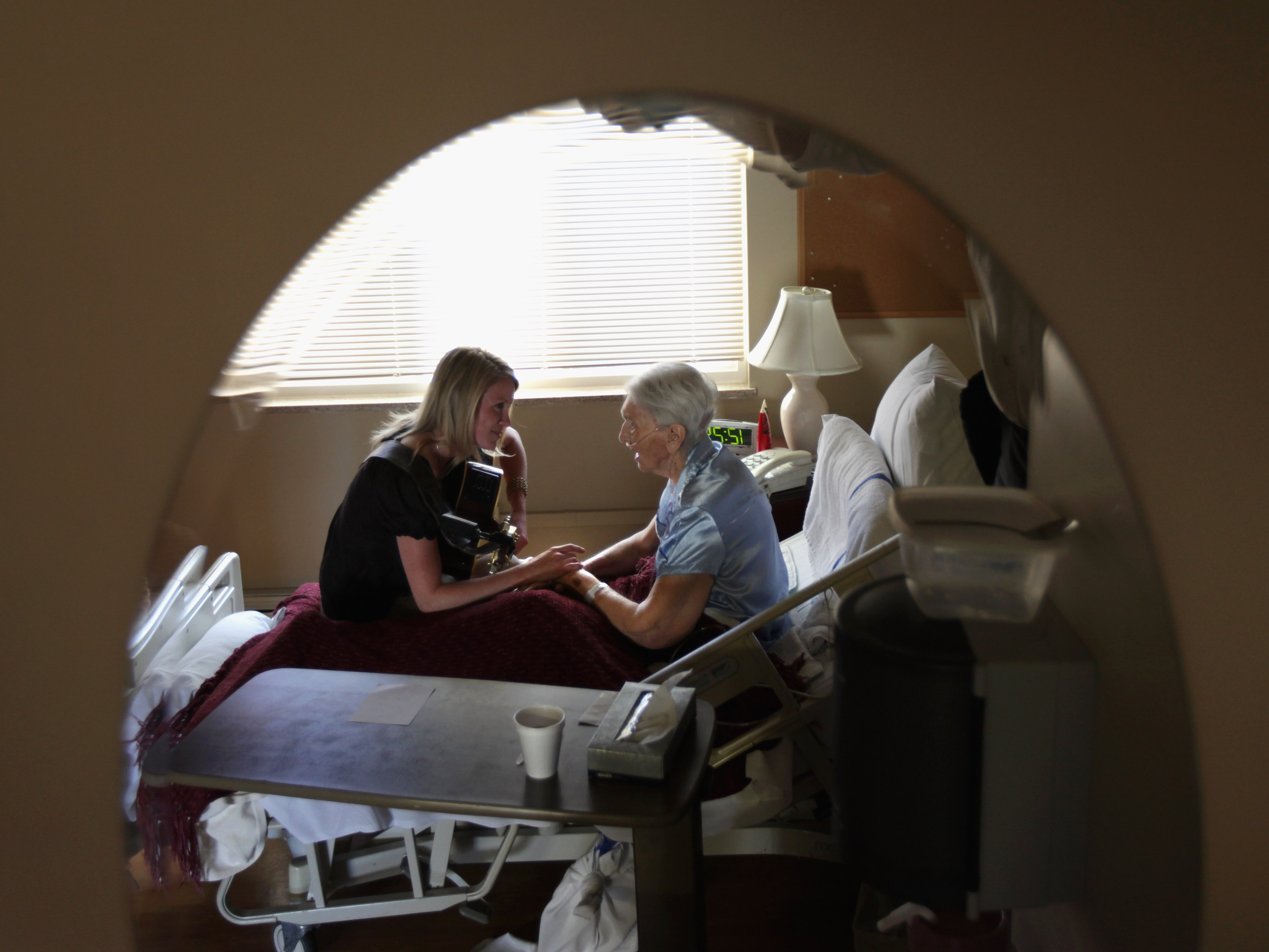 Terminally ill hospice resident Evelyn Breuning, 91, right, sits with music therapist Jen Dunlap in her bed in August 2009 in Lakewood, Colo. The nonprofit hospice, the second oldest in the United States, accepts the terminally ill regardless of their ability to pay, although most residents are covered by Medicare.