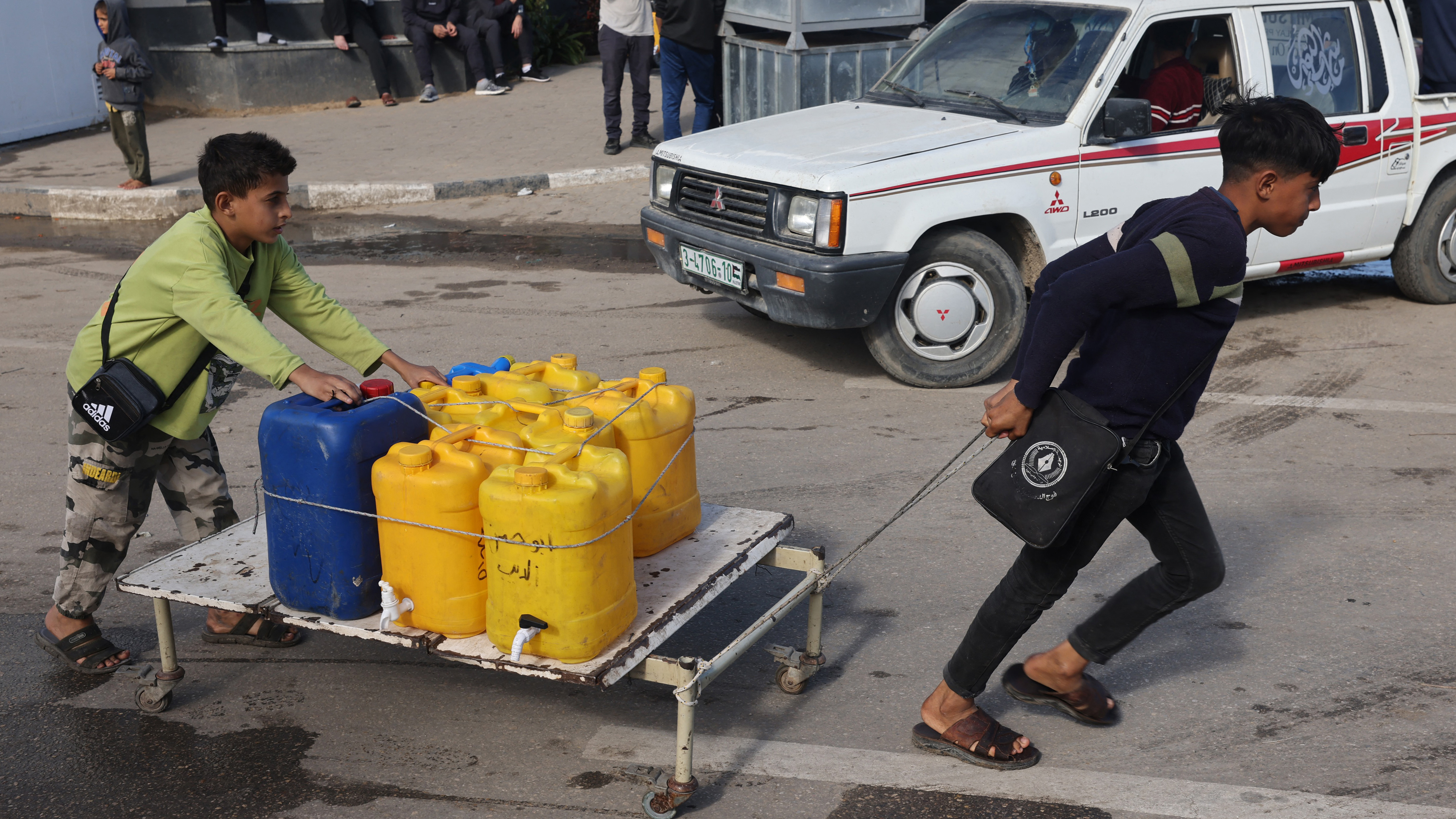 Internally displaced Palestinian children use a makeshift wheeled cart to haul water in Rafah in the southern Gaza Strip on Sunday, as battles continue between Israel and the militant group Hamas. (AFP via Getty Images)