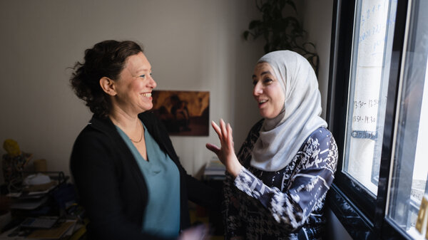 The Hand in Hand Jerusalem school principal Efrat Meyer, who is Jewish, and vice principal Engie Wattad, who is Arab Muslim, smile and chat with each other.