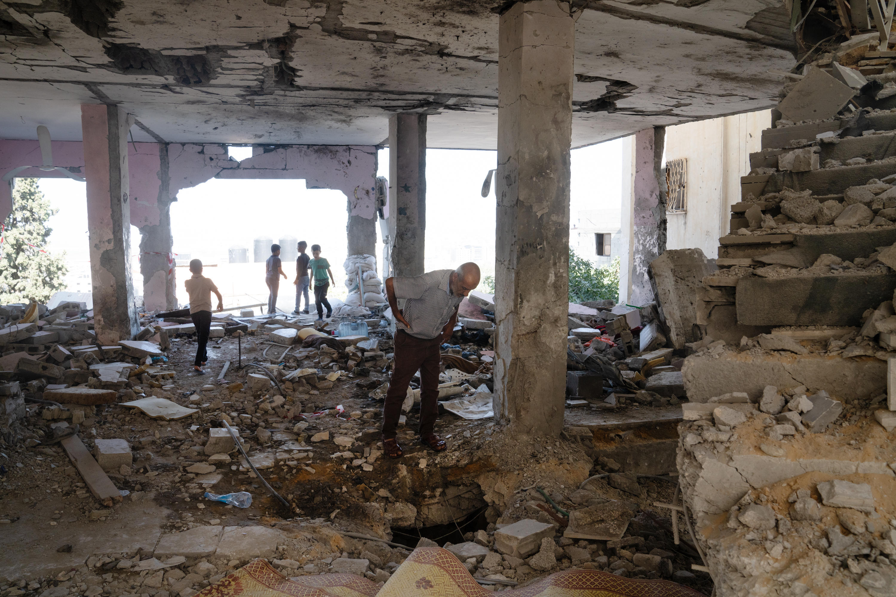 JENIN, WEST BANK - People walk through the ruins of Al-Ansar mosque in Jenin Refugee camp that was struck by Israeli military in retaliaition to the Hamas attack. Click here for the full story.
