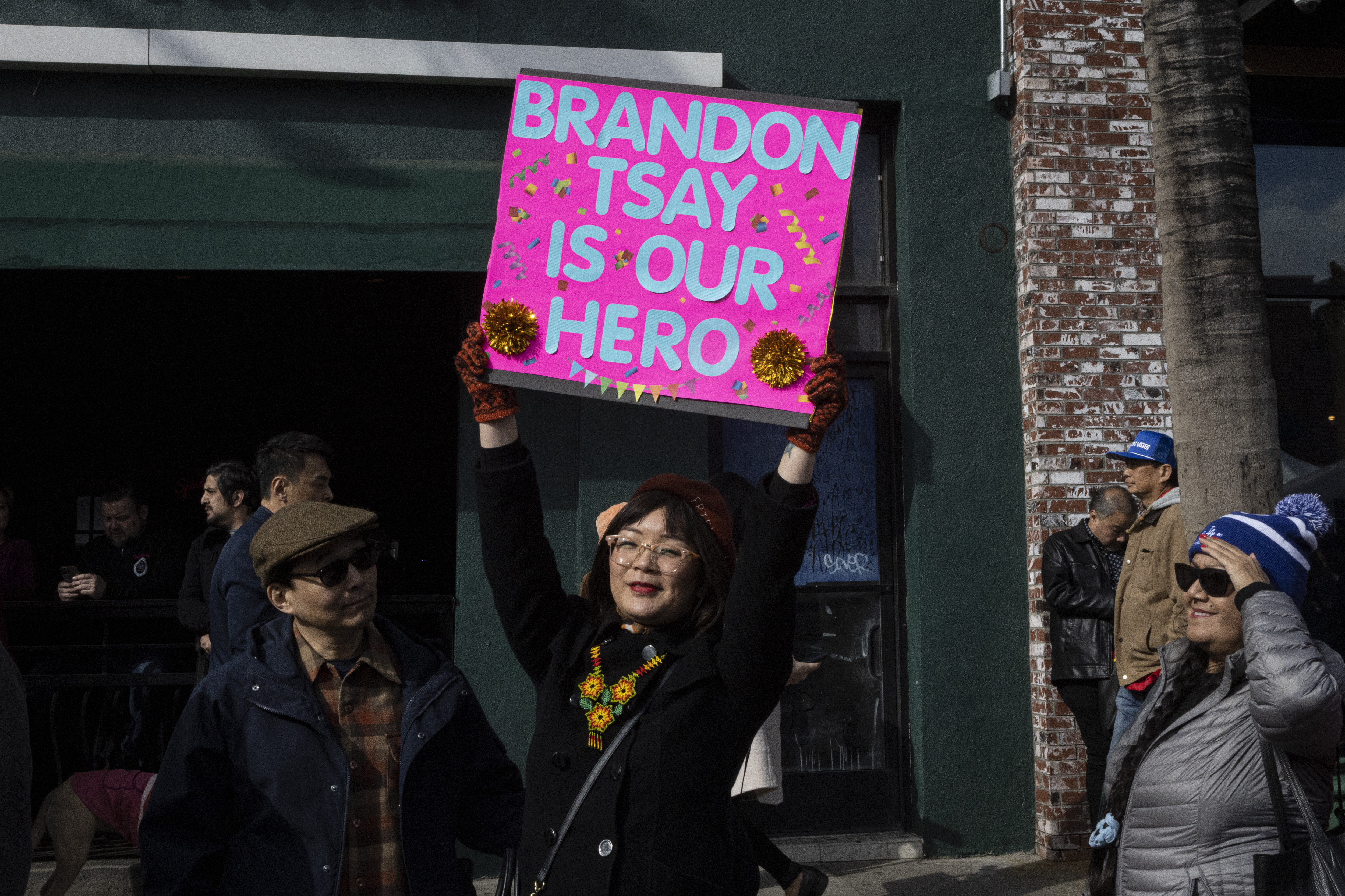 ALHAMBRA, Calif: Becki Peng holds a sign honoring Brandon Tsay as she waits in line to meet him at the Alhambra Lunar New Year Festival. Tsay was praised for preventing a gunman, who had killed 11 people and injured 10 others at a dance hall, from carrying out a second attack. See the story.