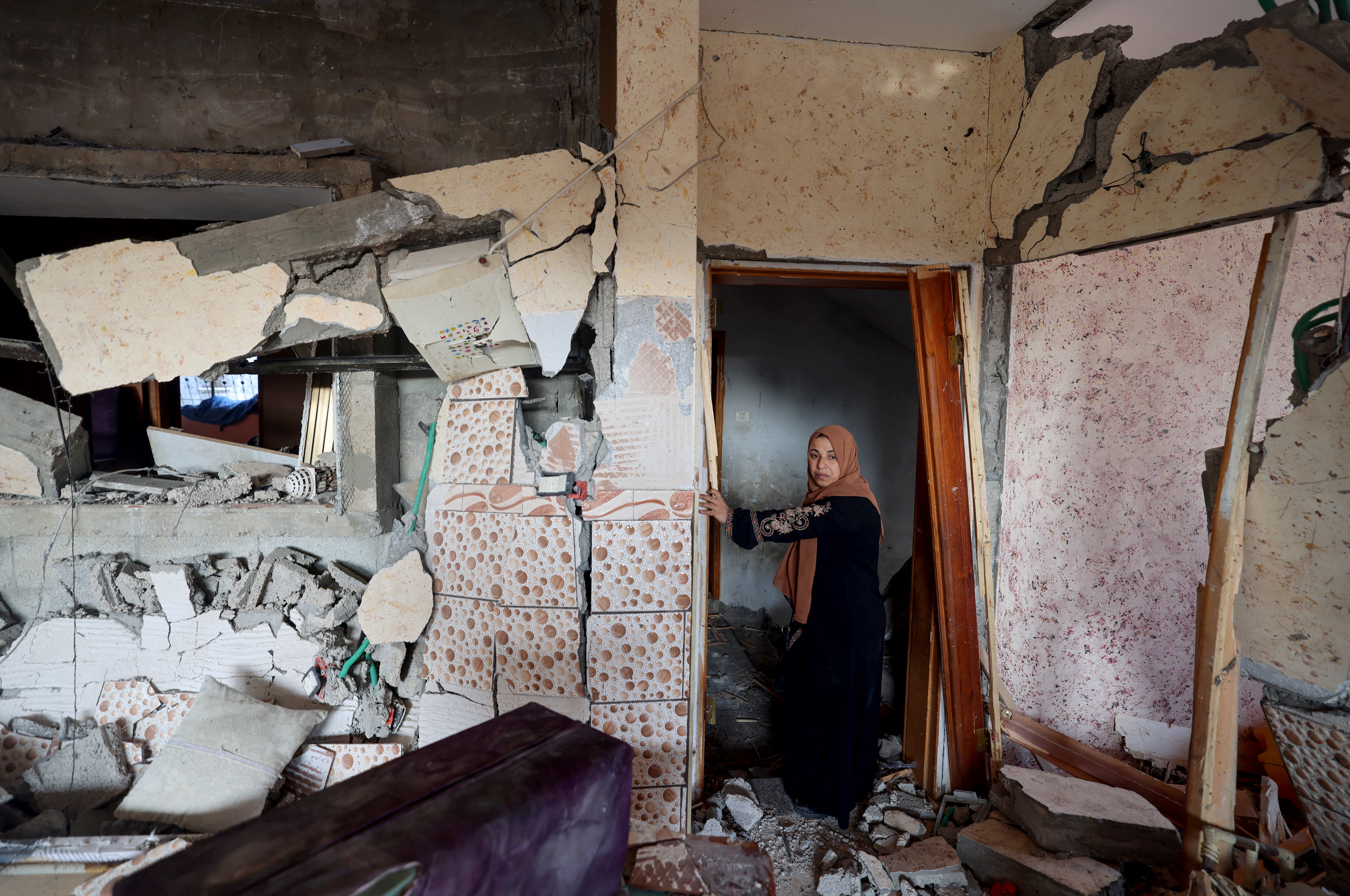 A woman stands in her damaged house in Rafah, in the southern Gaza Strip, on Friday, following Israeli bombardment amid continuing battles between Israel and the Palestinian militant group Hamas. (AFP via Getty Images)