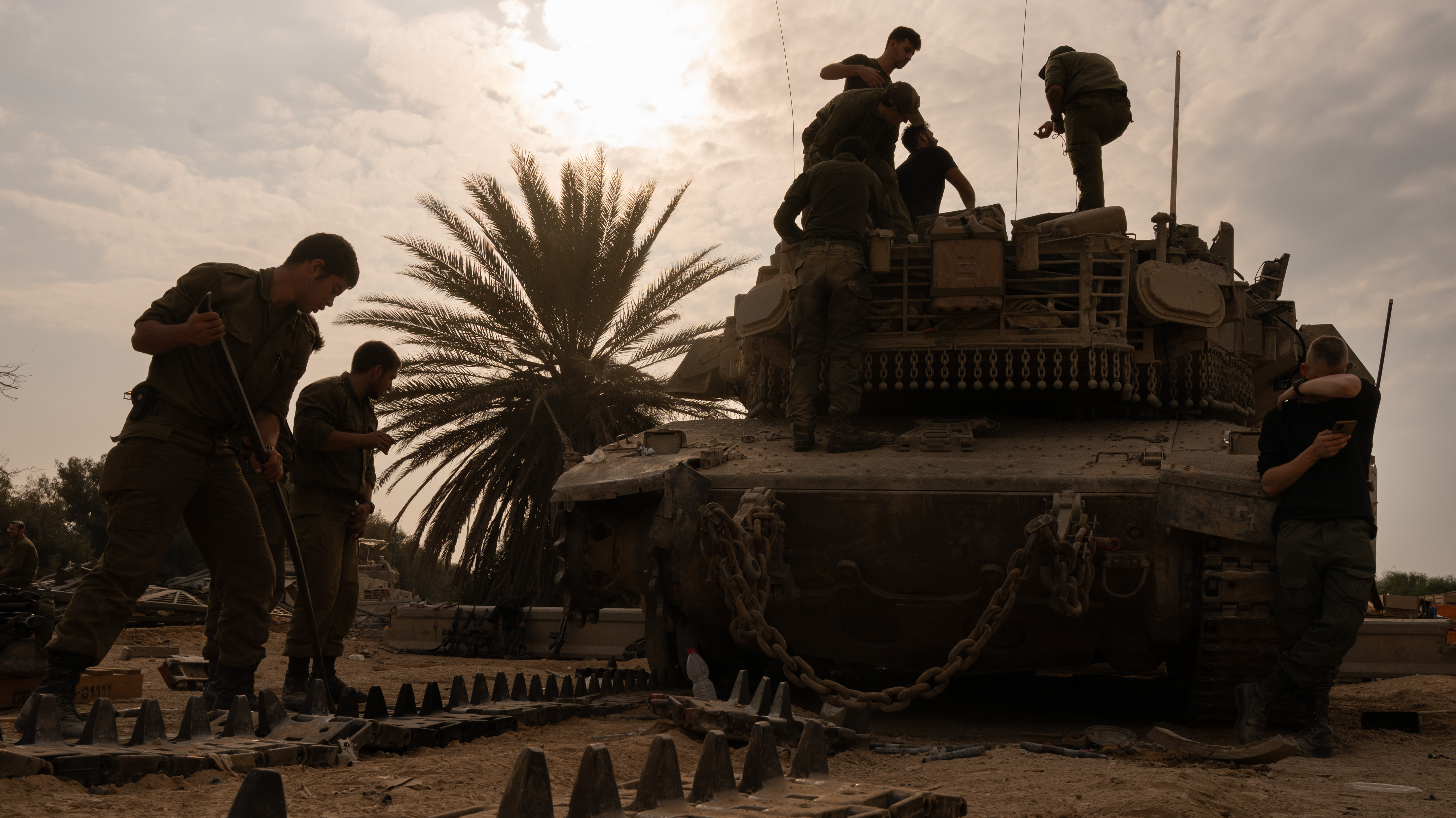 Israeli soldiers work on artillery after coming out of Gaza and across the border into Israel on Dec. 28, 2023.