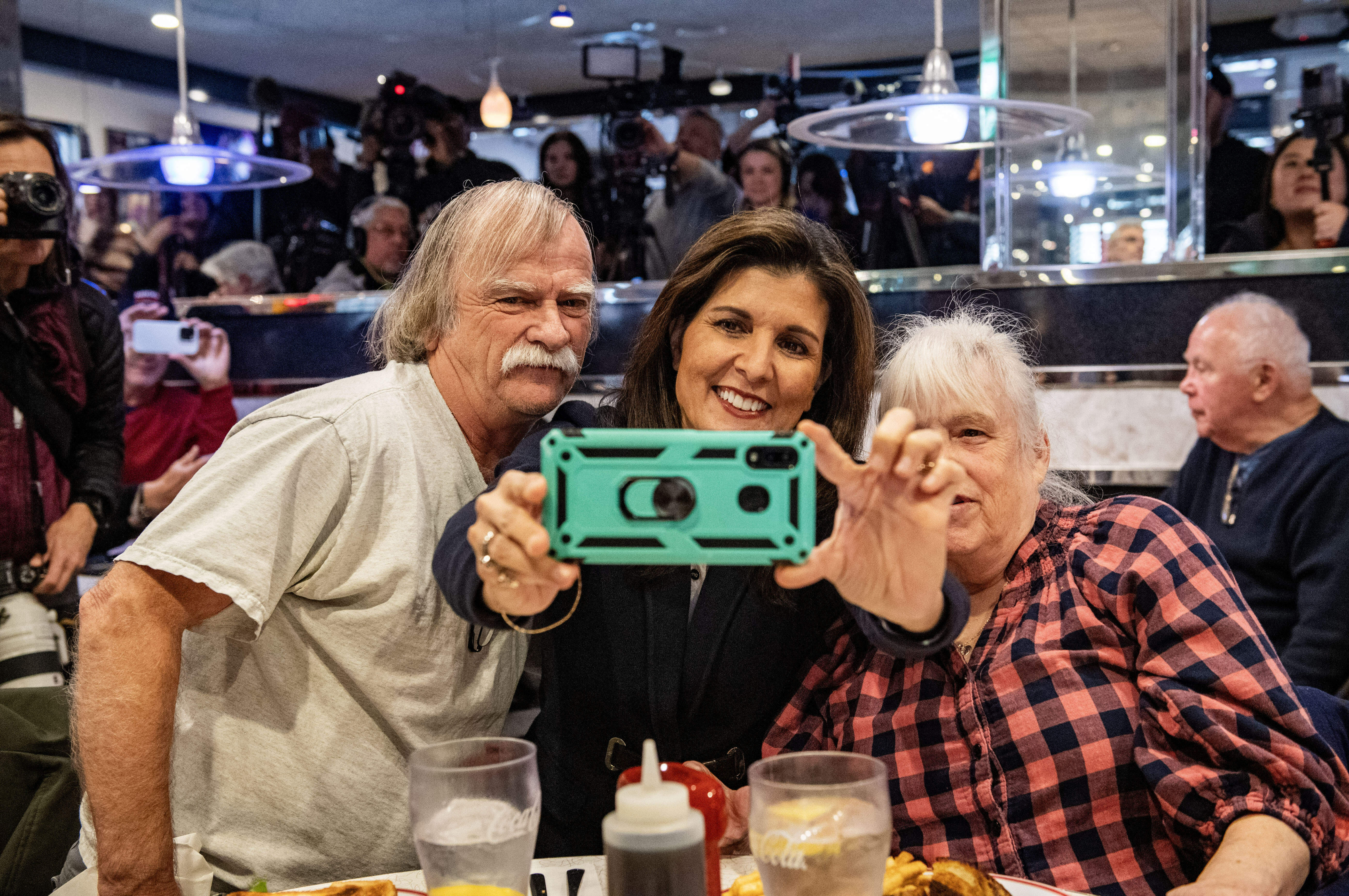 Former U.N. ambassador and 2024 Republican presidential hopeful Nikki Haley takes a selfie with voters at Mary Anne's Diner in Amherst, N.H. (AFP via Getty Images)