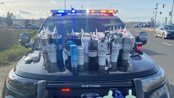 A police car filled with Stanley tumblers.