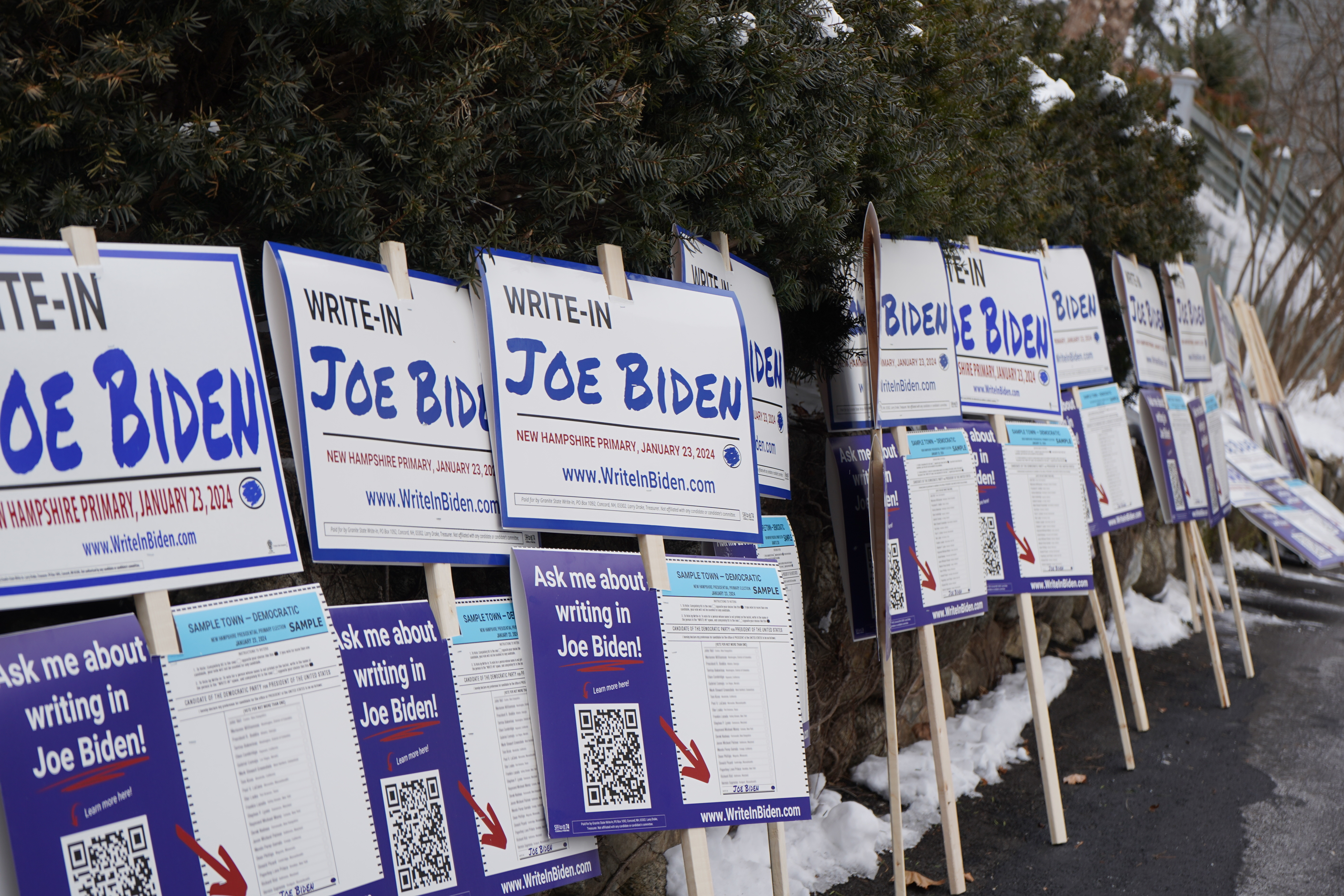 Signs line a driveway in Concord, N.H., waiting for volunteers to pick them up. President Biden is not on the New Hampshire primary ballot because of a dispute over Democratic Party rule changes. (NPR)