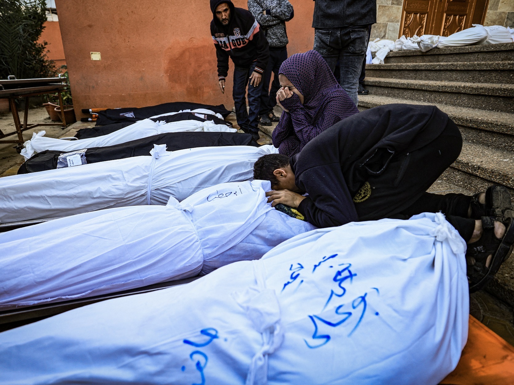 Relatives mourn over the bodies of people killed when the tent where they were sheltering was hit by Israeli bombardment, at the morgue of the Nasser medical center in Khan Younis in the southern Gaza Strip on Jan. 4. (AFP via Getty Images)