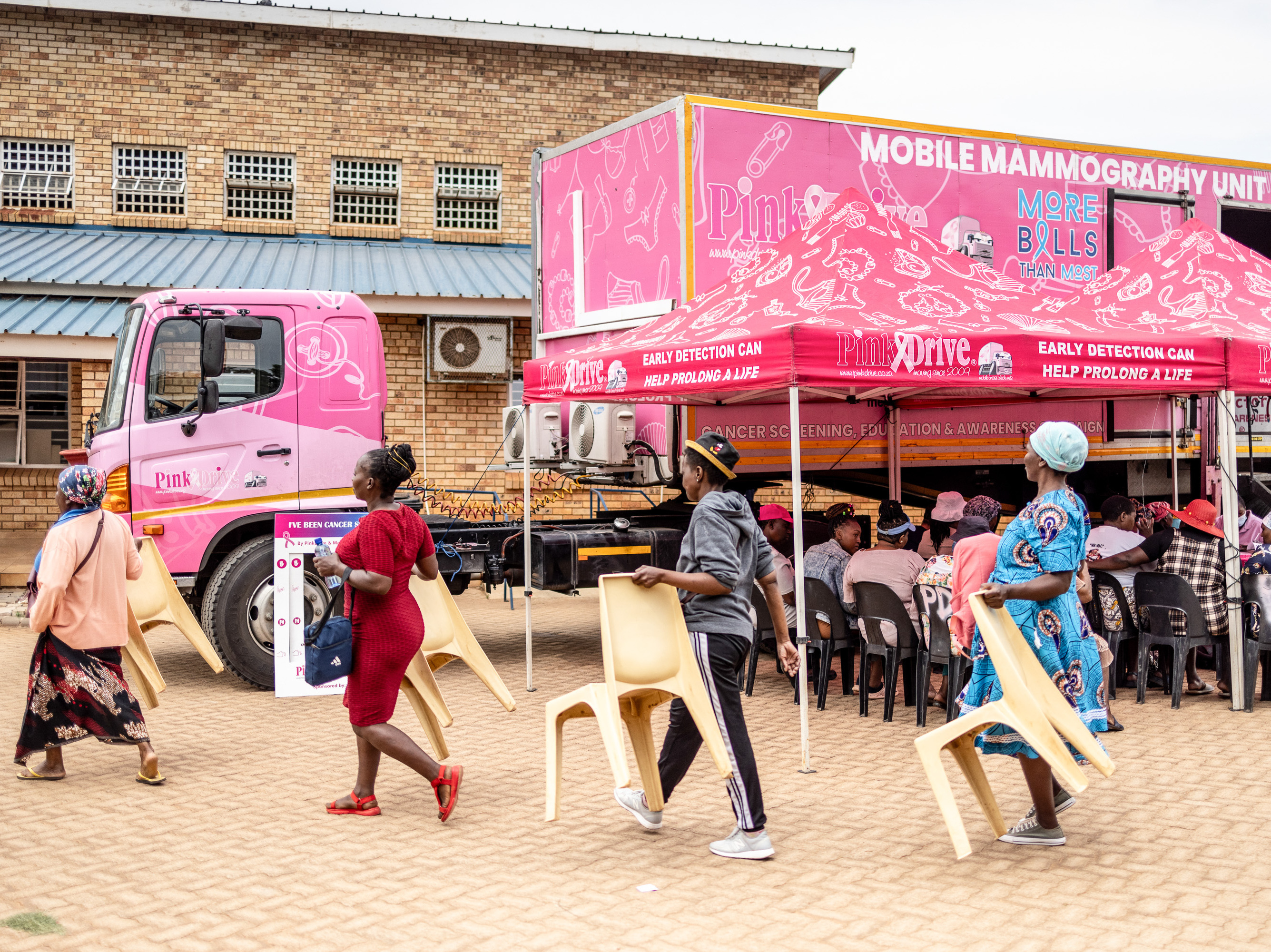 Patients carry chairs for their wait to be seen on screening day at a clinic in Johannesburg. (Roberta Ciuccio/AFP via Getty Images)