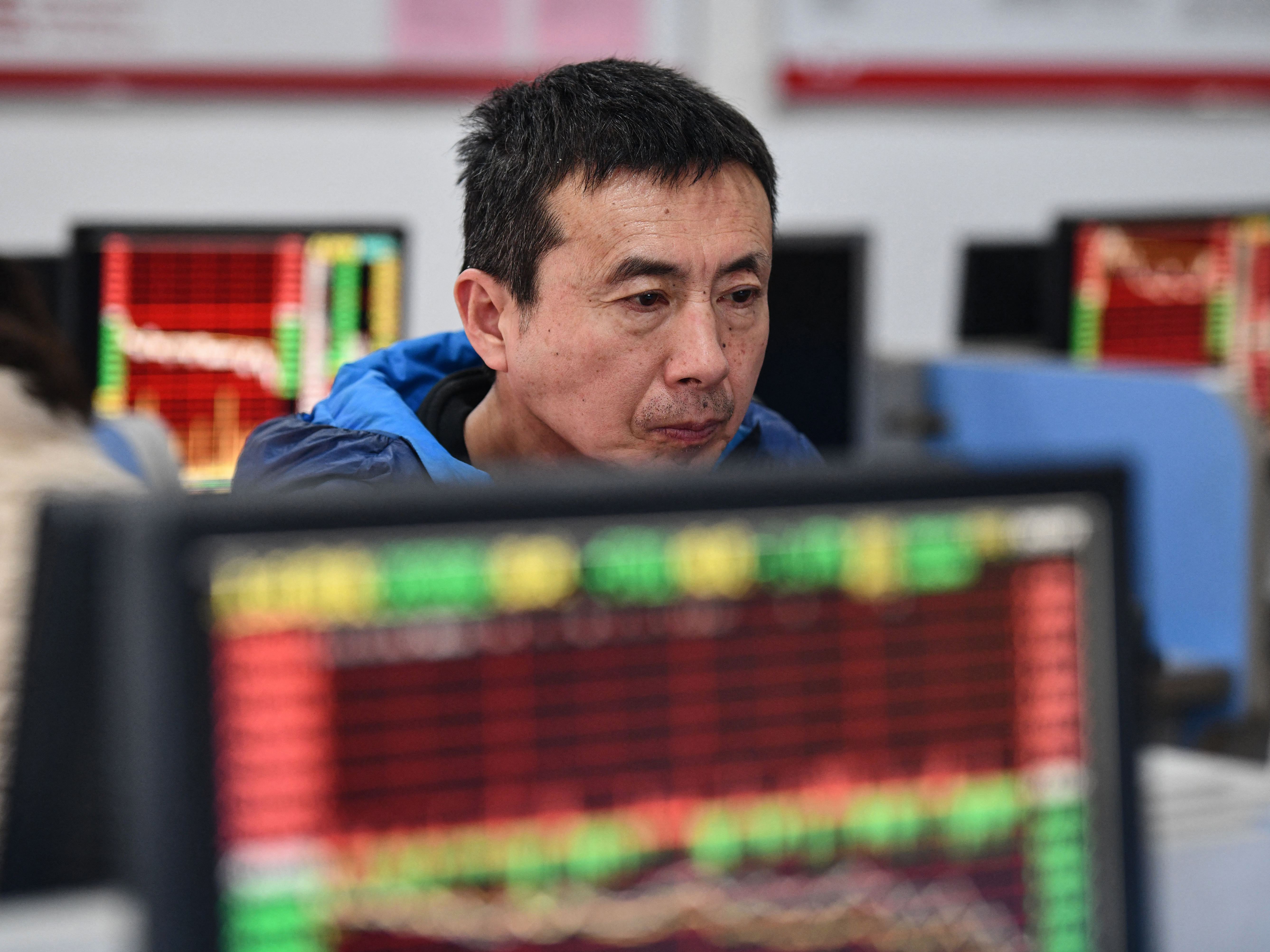 An investor looks at screens showing stock market movements at a securities company in Fuyang in China's eastern Anhui province on Jan. 17. (AFP via Getty Images)