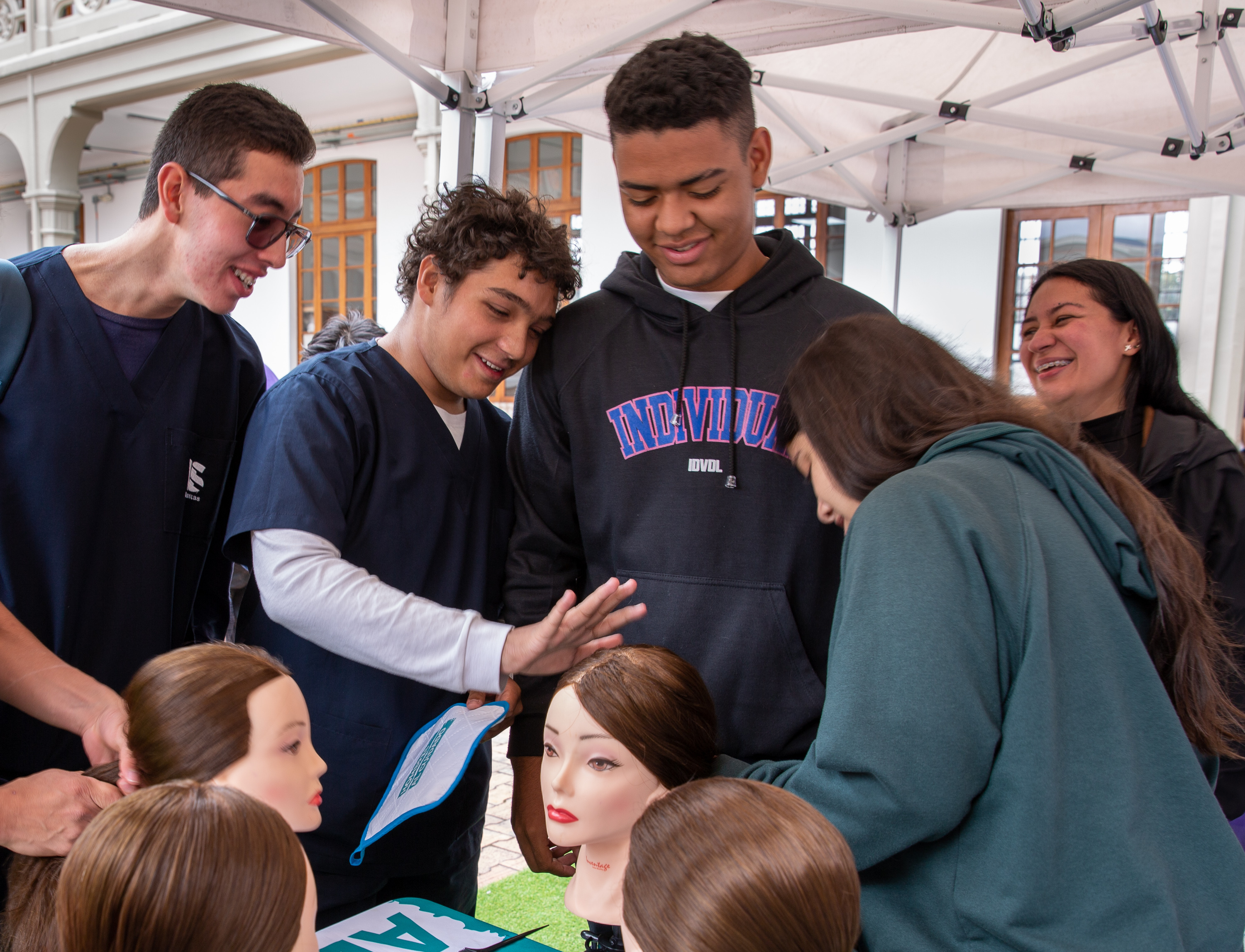 Hey, guys, wanna know how to diaper a baby or make a ponytail? Try the School for Men 2 Mannequin heads offer a chance for men to practice hairstyling. Luis Rodríguez (second from left), a medical student, says the lesson made him appreciate his mom's workload at home. As for ponytails, he said he'd tried to do his sister's hair before, but this was the first time he felt confident about the result. "It looked really, really good, the way my mom does it," he says.