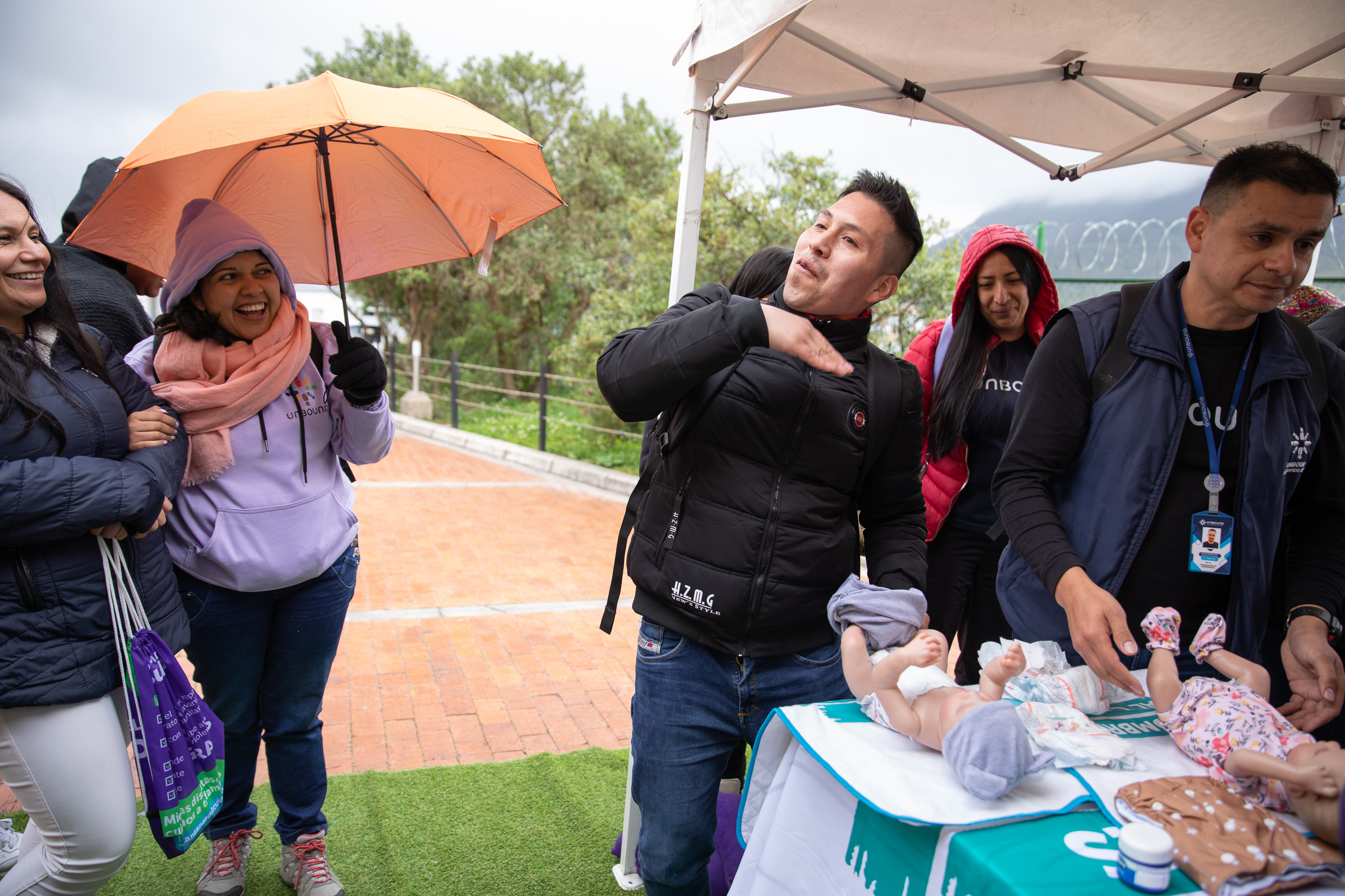 Hey, guys, wanna know how to diaper a baby or make a ponytail? Try the School for Men 3 Nelson Alexander Yaguara pretends to wave away the stink of a soiled baby diaper at a pop-up workshop in Bogotá's San Cristóbal neighborhood.