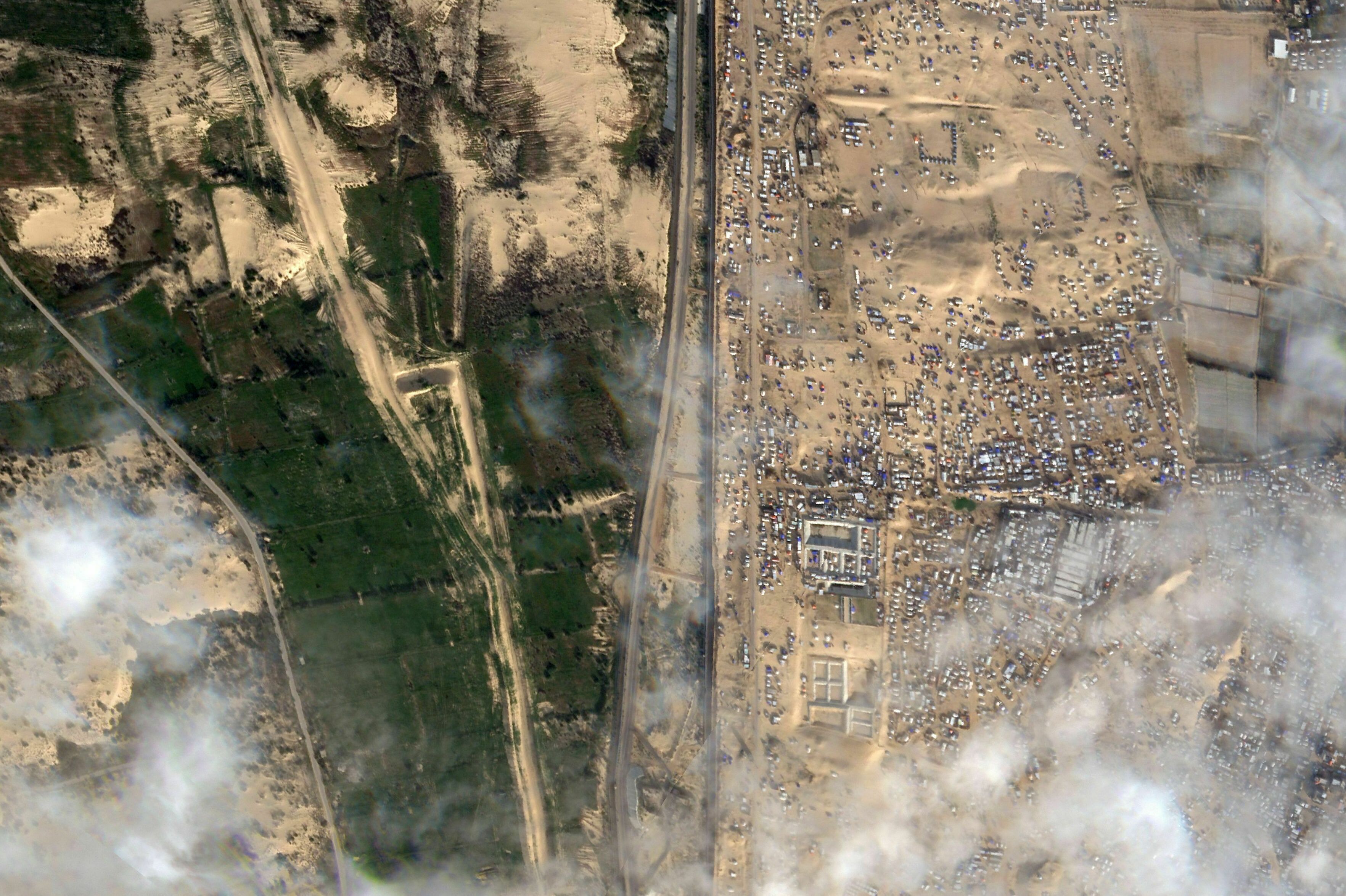 This Feb. 18 satellite photo shows displaced Palestinians crammed into southern Gaza on the right. Israel is threatening to attack the border town of Rafah, where more than 1 million Palestinians are now living. On the left is the vast, empty expanse of Egypt's Sinai Peninsula. Egypt says it won't allow Palestinians into Egypt because it fears they might not be allowed back into Gaza. (Planet Labs PBC)
