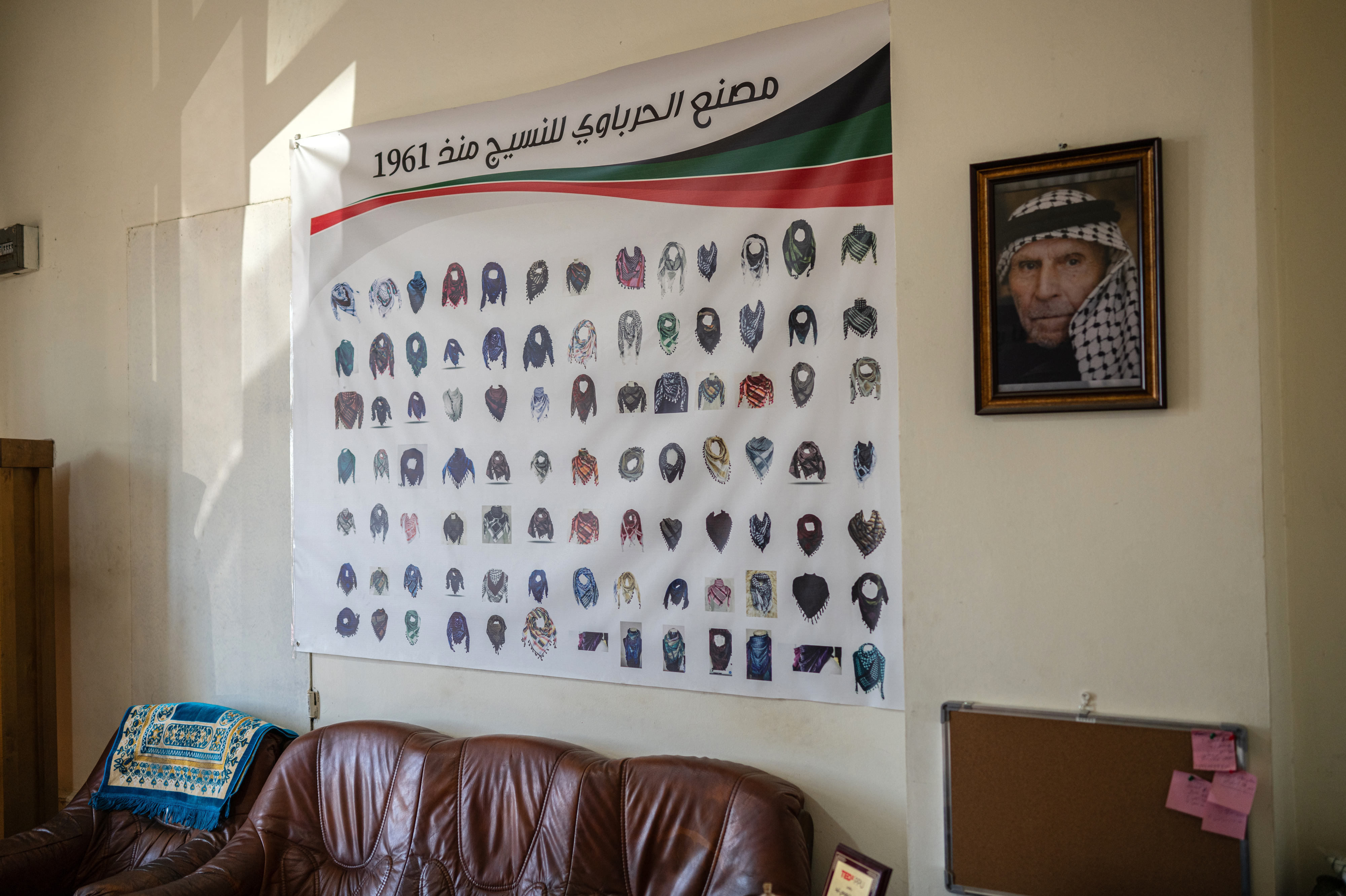 One-of-a-kind West Bank factory ships the colors of Palestinian resilience worldwide 1 A poster of different keffiyeh designs is displayed beside a portrait of the Hirbawi keffiyeh factory's founder, Yasser Hirbawi.
