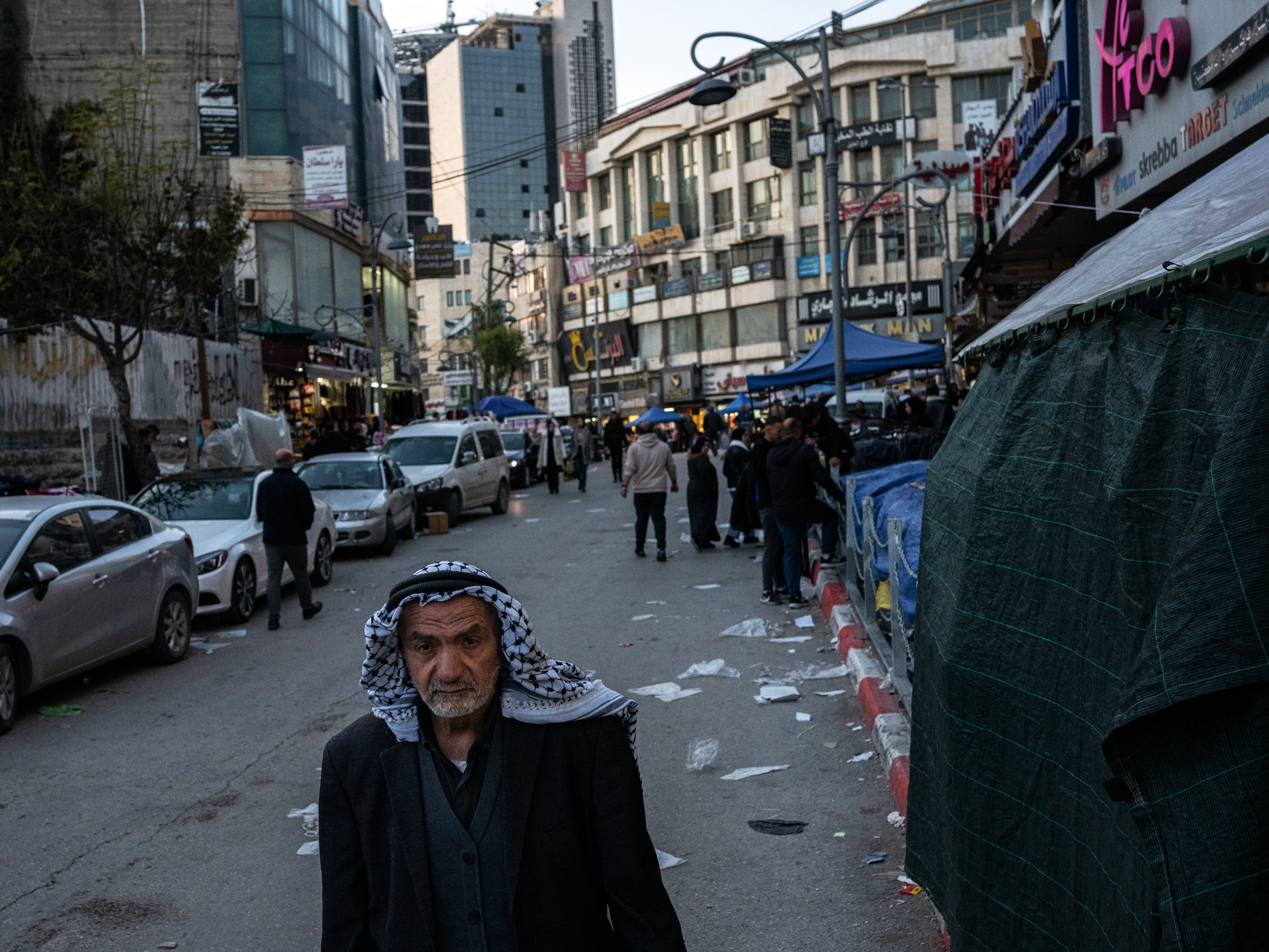 One-of-a-kind West Bank factory ships the colors of Palestinian resilience worldwide 4 A man wearing a traditional Palestinian keffiyeh walks down a street in Hebron.