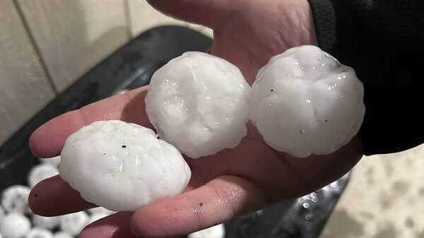 Large chunks of hail held in a person's hand on Wednesday night, in Shawnee, Kan.