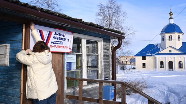 A member of a local election commission prepares a polling station with a sign that reads "Election of the President of Russia March 15-17 2024" for early voting in the village of Sennaya Guba, Republic of Karelia, on March 10.