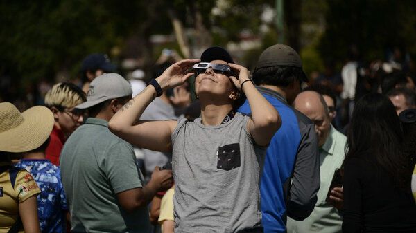  A woman watches an annular solar eclipse on October 14, 2023, using special solar filter glasses at the National Autonomous University of Mexico.