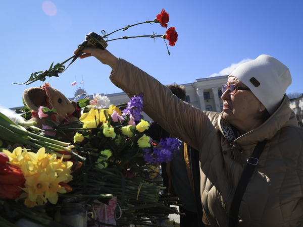 A woman places flowers in memory of the victims of the attack in Moscow, in the center of Simferopol, in Russian-held Crimea, Sunday, March 24, 2024.