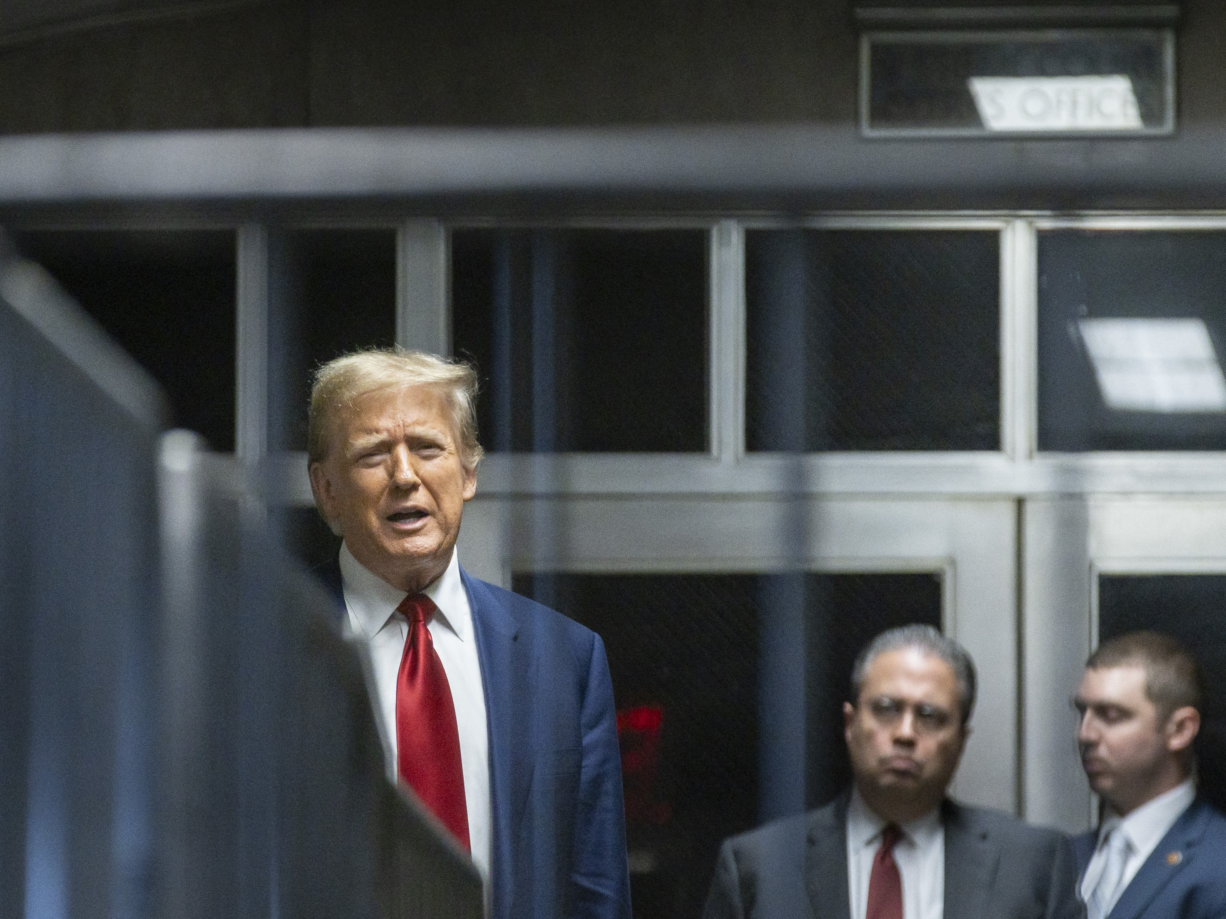 Former President Donald Trump speaks to the press in a hallway outside the courtroom at the end of a hearing to determine the date of his trial for allegedly covering up hush money payments linked to extramarital affairs, at Manhattan Criminal Court in New York City on March 25. (Pool/AFP via Getty Images)
