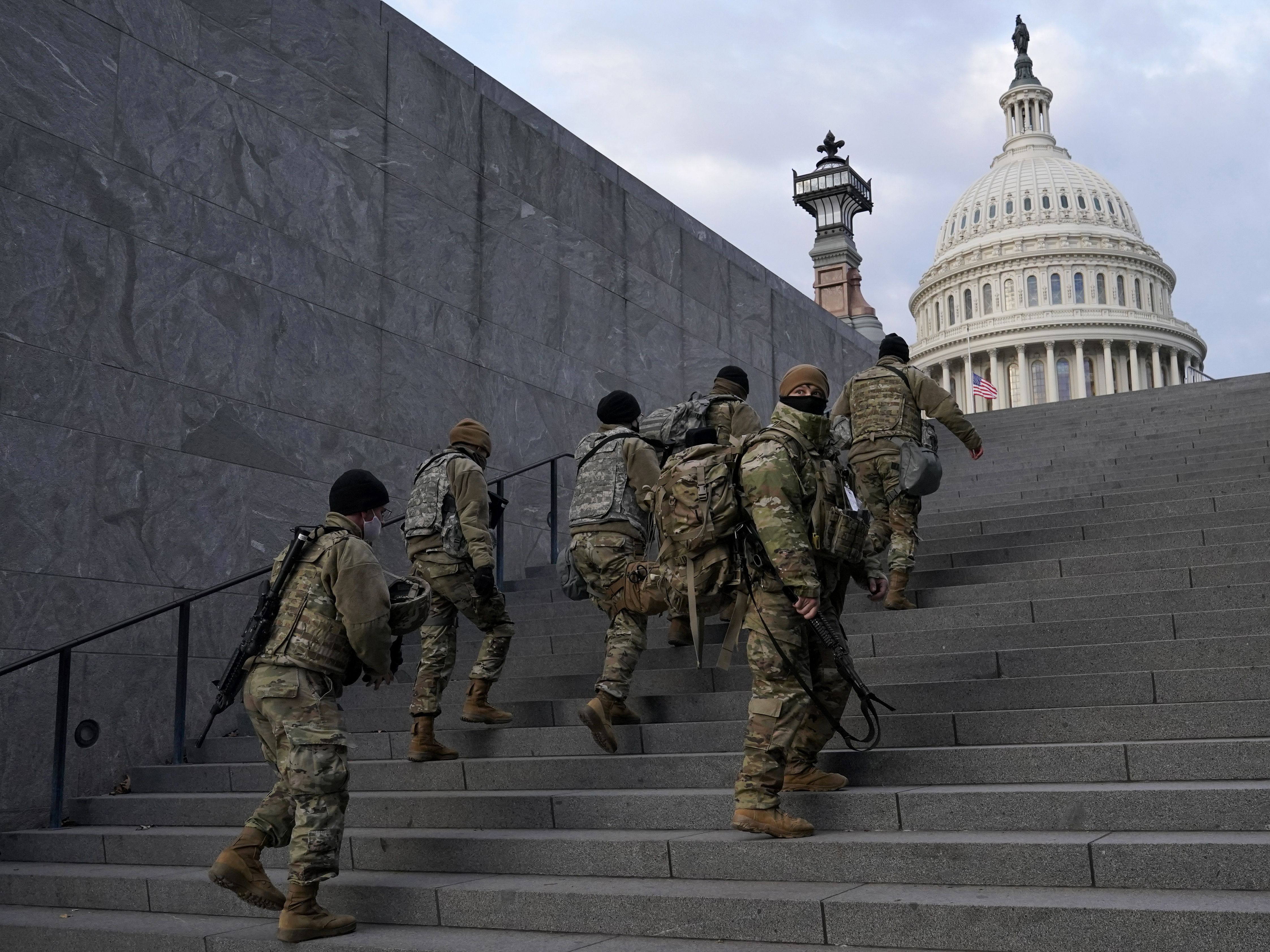 National Guard members take a staircase toward the U.S. Capitol building before a rehearsal for President-elect Joe Biden