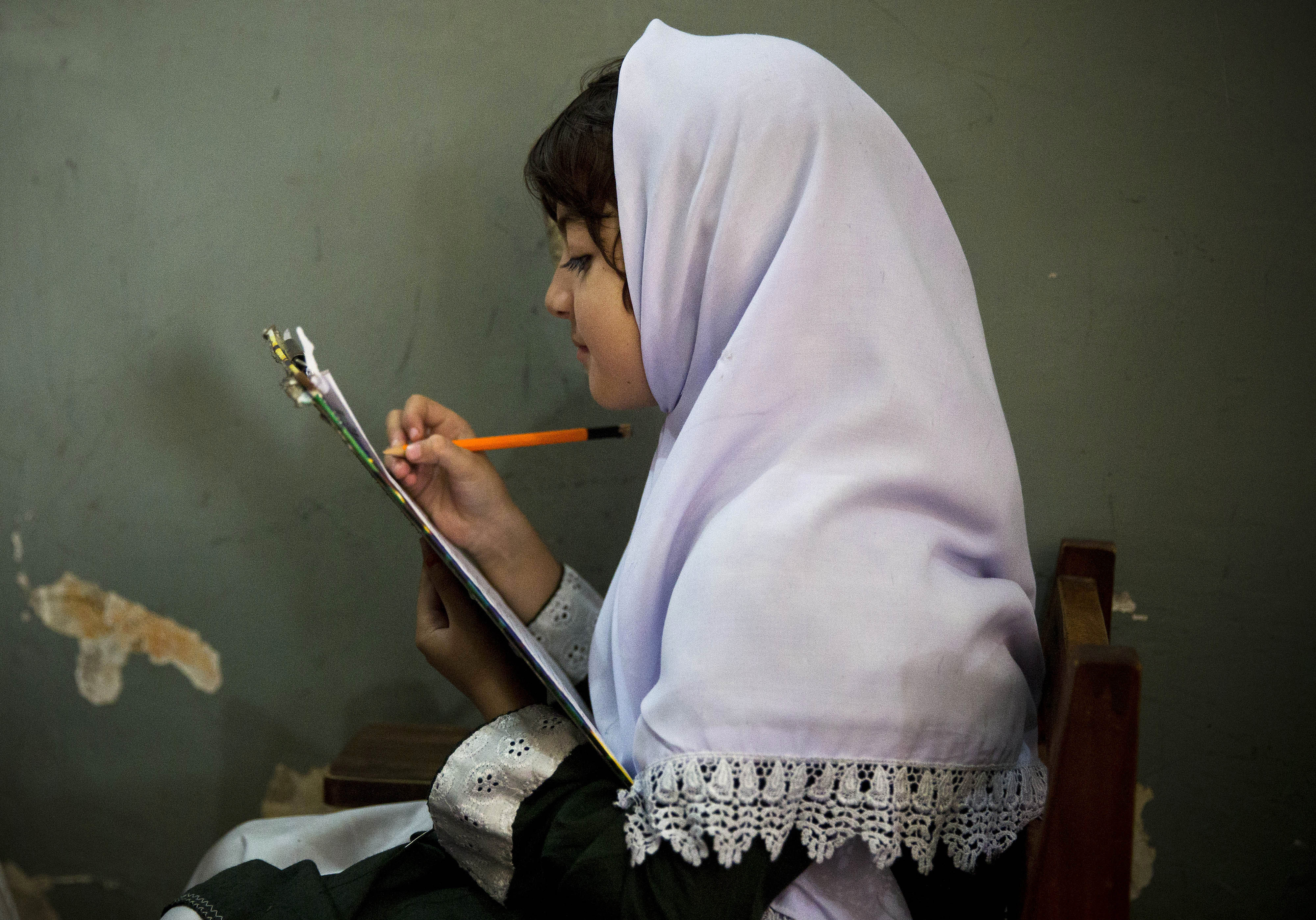 A young Pakistani girl works on her midterm papers in a school in Mingora, Swat Valley, Pakistan, on Oct. 5, 2013, a year after Malala Yousafzai was shot in the head by a Taliban gunman.