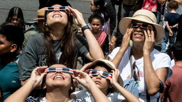 People watch the annular eclipse of the sun at the planetarium of the University of Costa Rica (UCR) in San Jose, on October 14, 2023. 