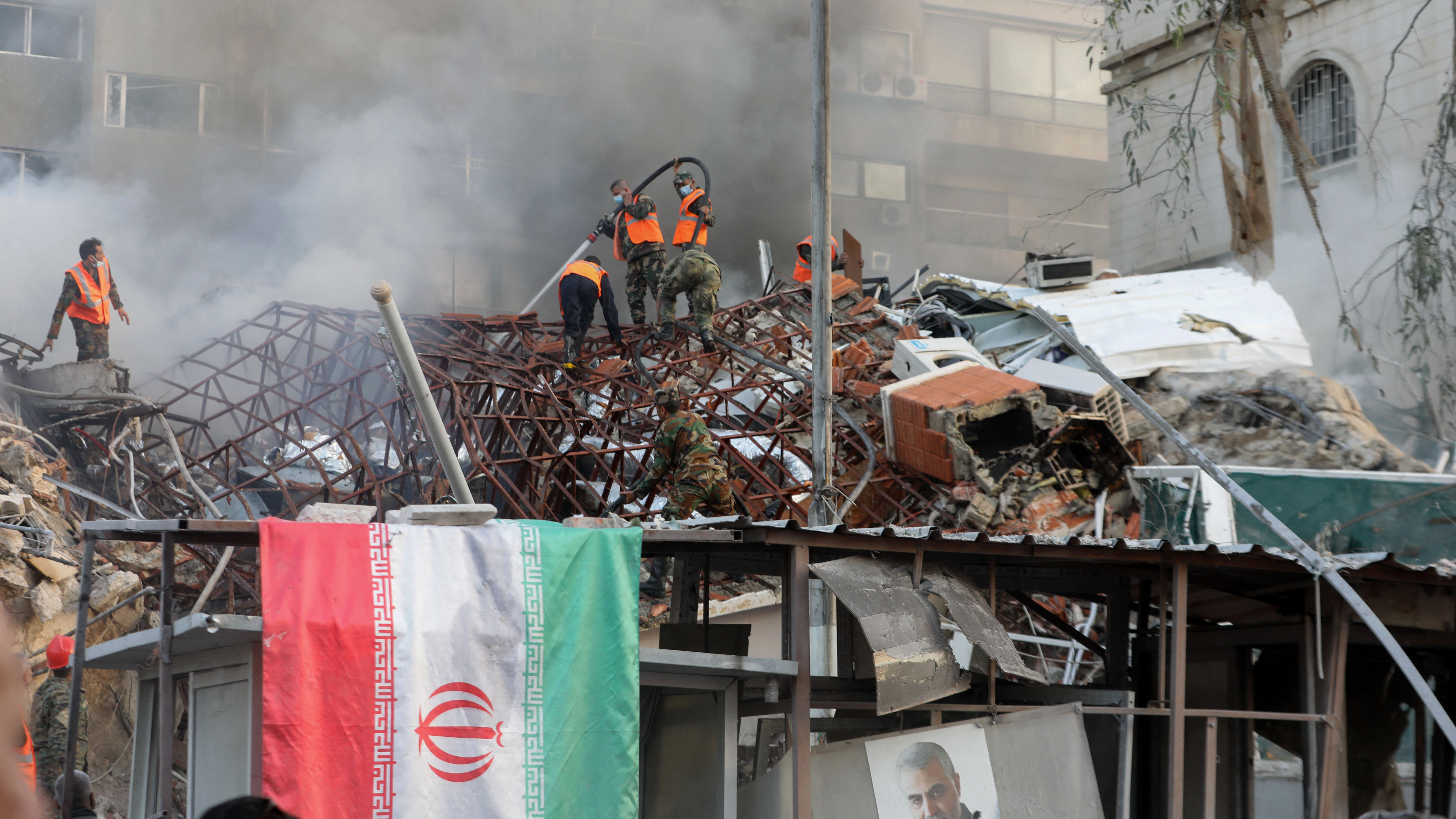 Emergency and security personnel extinguish a fire at the site of strikes that hit a building annexed to the Iranian embassy in Syria's capital Damascus on April 1. Iran blames Israel for the attack. (AFP via Getty Images)