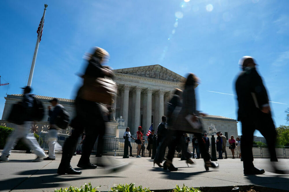 People walk by as supporters of Jan. 6 defendants gather outside of the Supreme Court on Tuesday. (Getty Images)