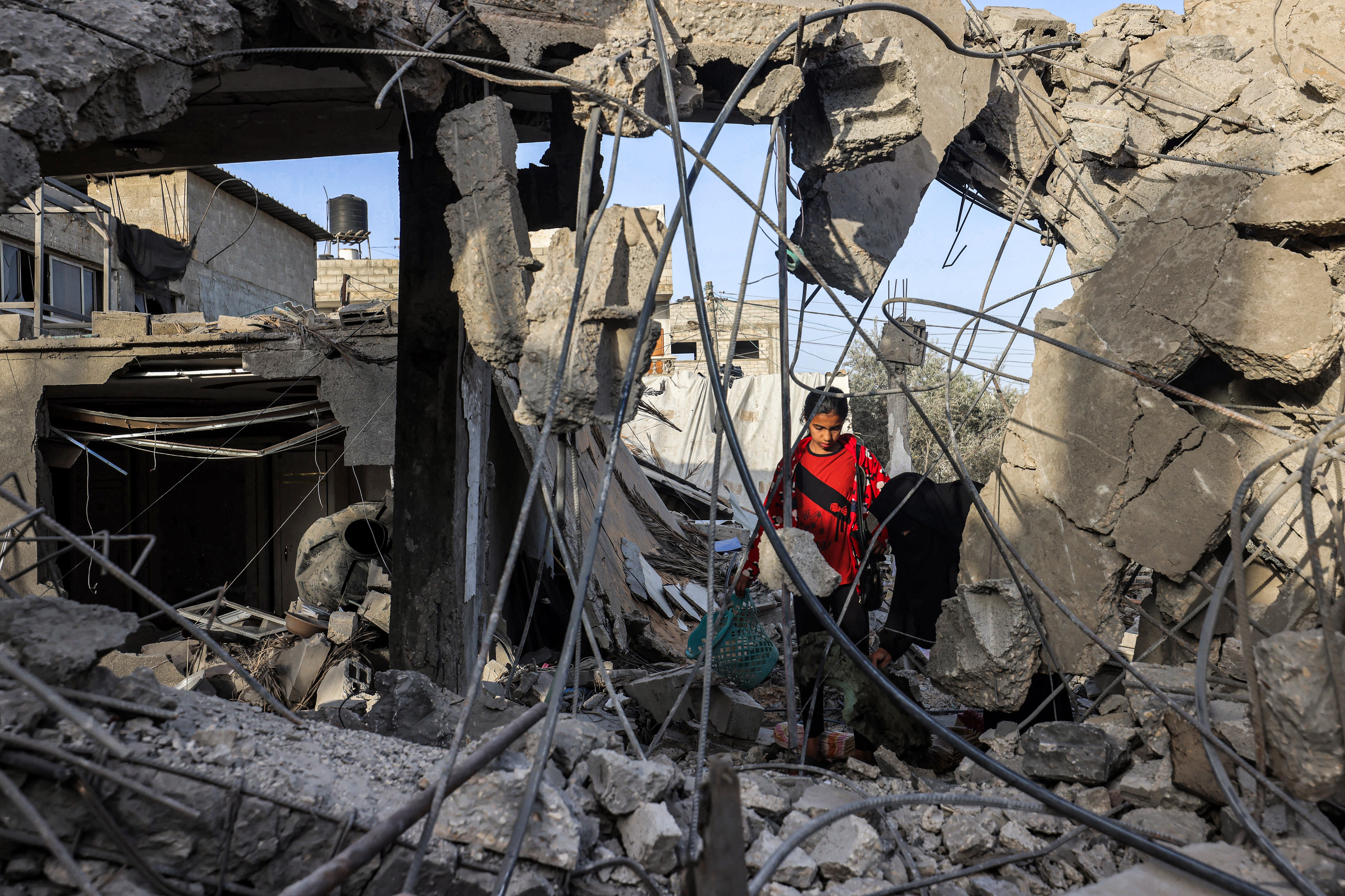 Amid the rubble of a collapsed building in Rafah, in southern Gaza, a woman and a girl search for items on April 24, following reported Israeli airstrikes overnight. (AFP via Getty Images)