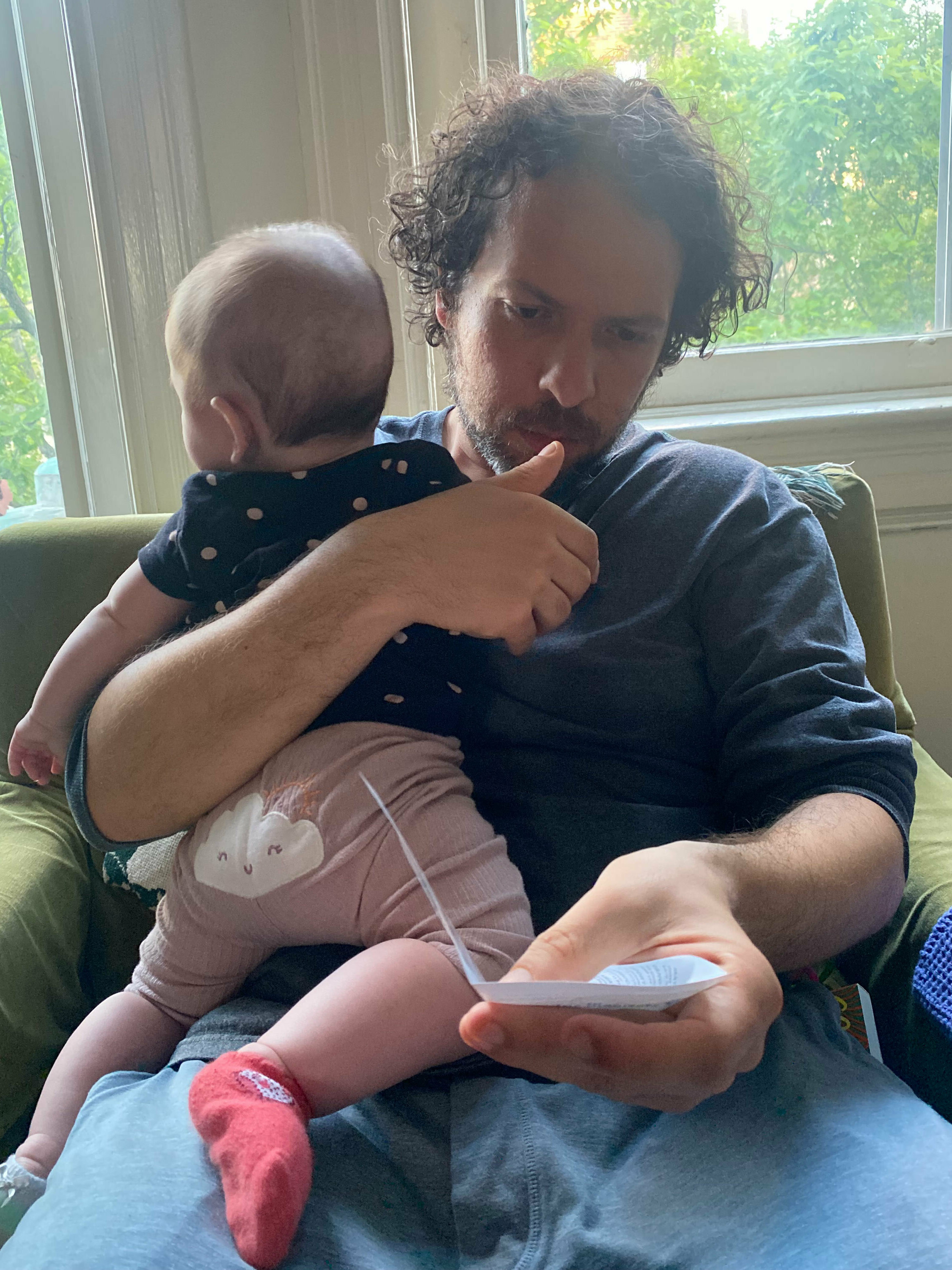 Oh dear! Baby gear! Why are the manuals so unclear? 1 Darius Tahir holds his nearly 5-month-old daughter while puzzling over an instruction manual.