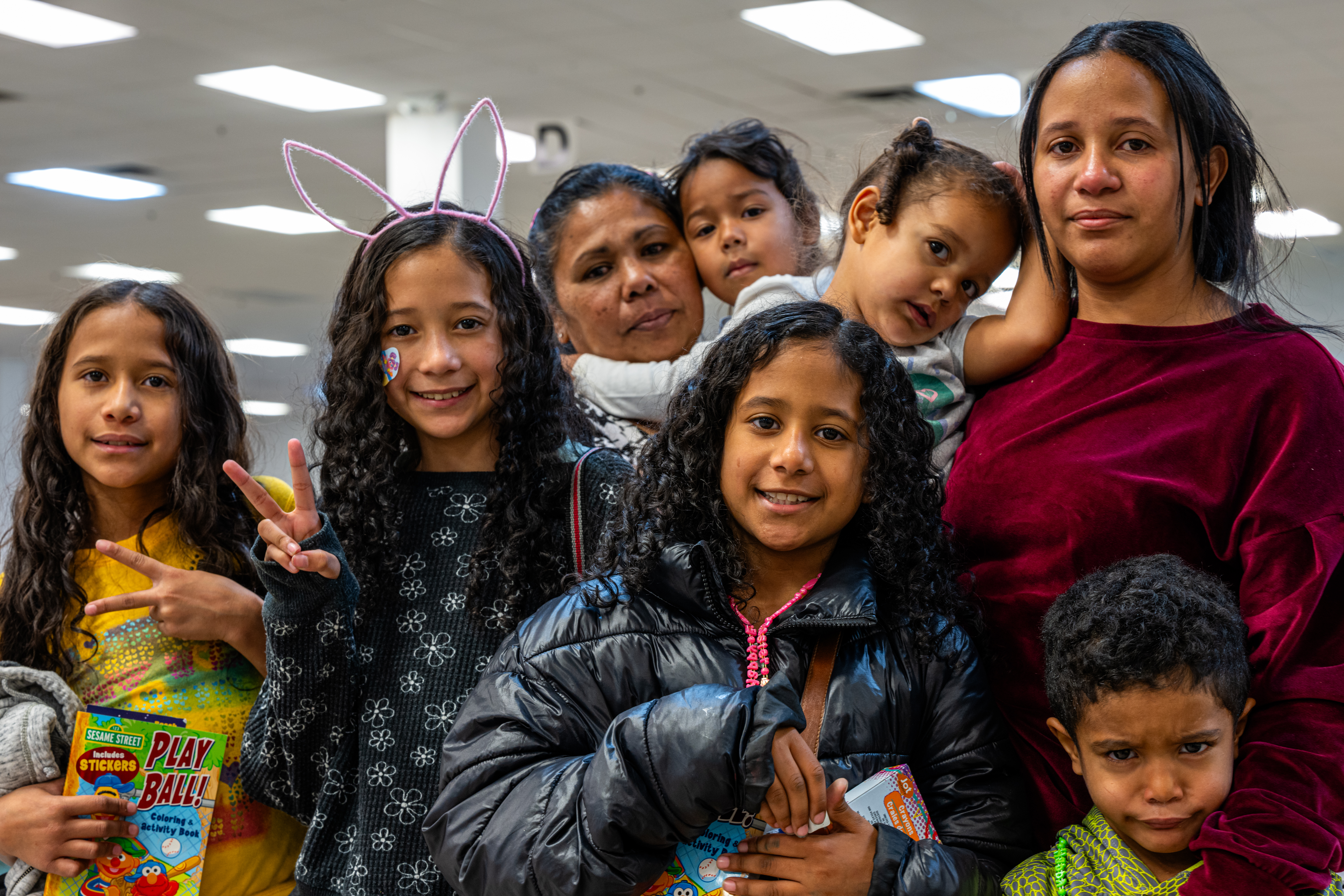 Yajaíra Peñaloza (left) and Marian Araujo pose with their children while waiting for their ride at the Casa Alitas shelter in Tucson, Ariz., on March 26. (Ash Ponders for NPR)