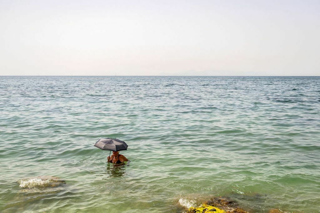 A woman takes refuge during Greece's July 2023 heat wave. El Niño helped drive global temperatures to new heights, making it the hottest year on record.