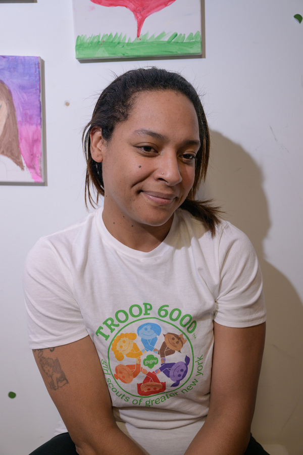 Giselle poses for a portrait, Girl Scout Troop 6000 volunteer and founder, after a meeting with their members - all residents of the Row Hotel, as newly arrived migrants - on Wednesday evening.