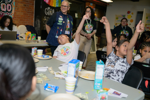 The girls excitedly raise their hands during an activity at Girl Scout Troop 6000's weekly meeting at the Row Hotel on Wednesday evening.