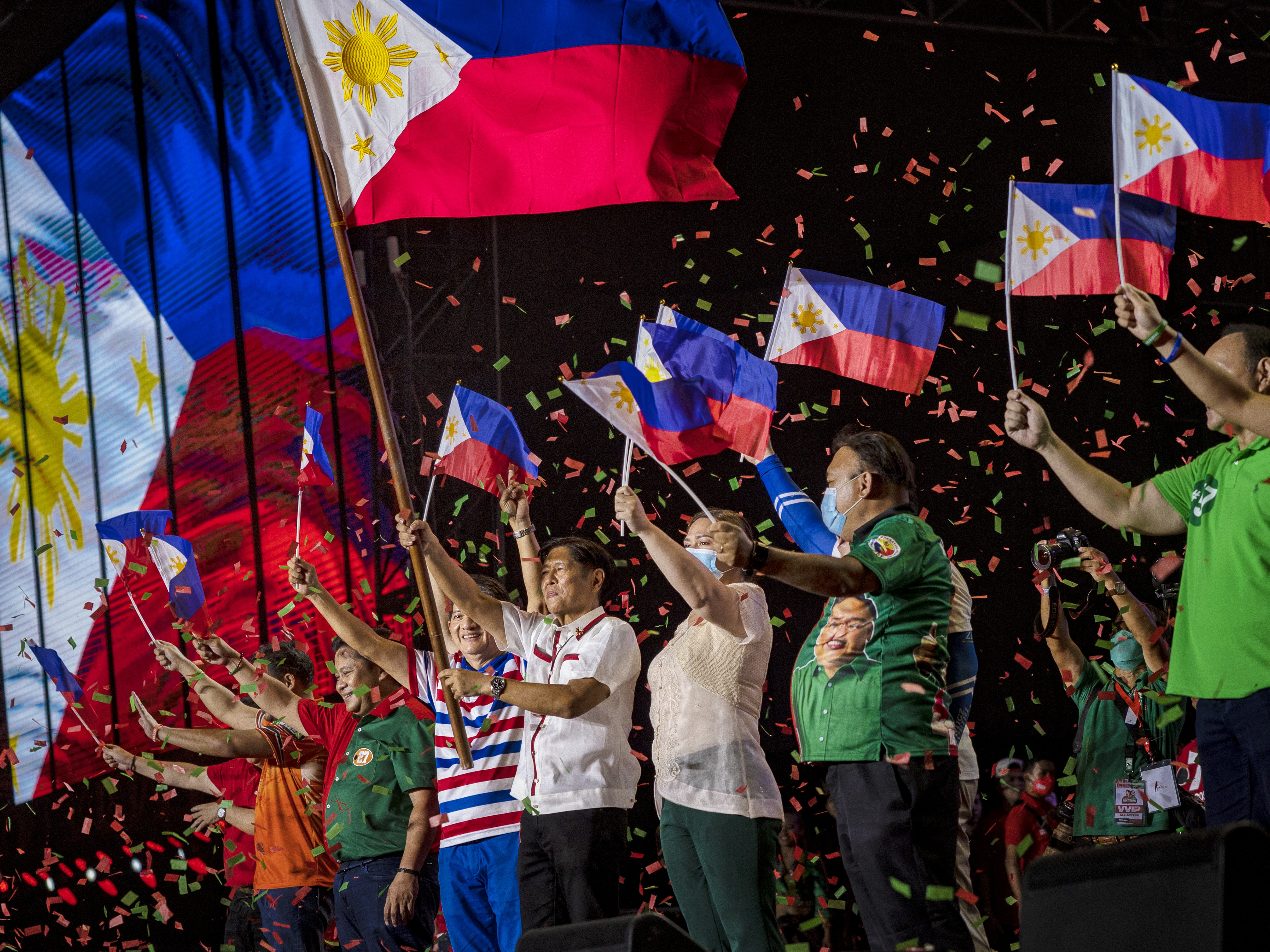 Ferdinand "Bongbong" Marcos Jr. and running mate Sara Duterte wave Philippine flags during their last campaign rally before the election on May 07, 2022 in Paranaque, Metro Manila, Philippines. (Photo by Ezra Acayan/Getty Images)