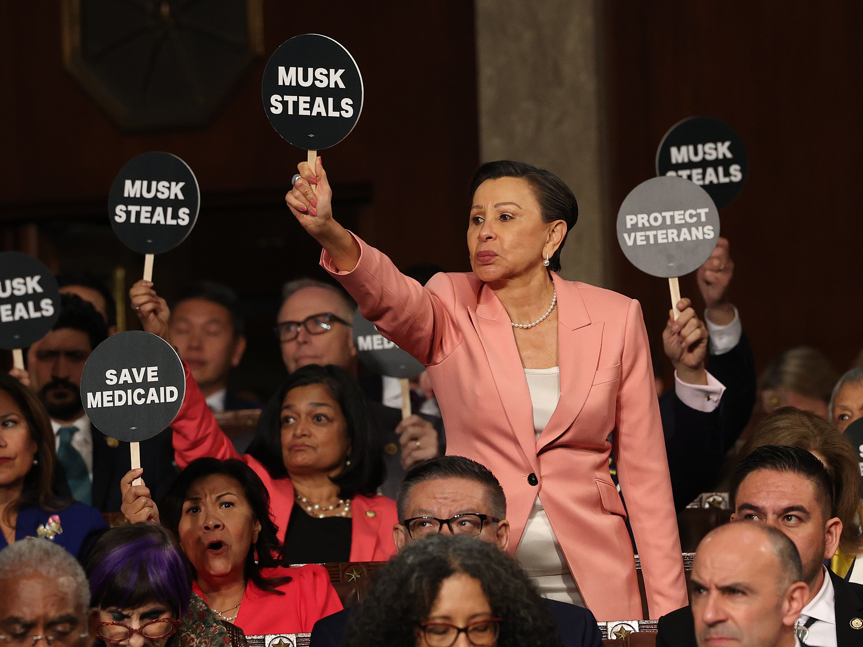 U.S. Rep. Nydia Velázquez (D-NY) holds a protest sign with fellow Democrats as U.S. President Donald Trump addressed a joint session of Congress at the U.S. Capitol.