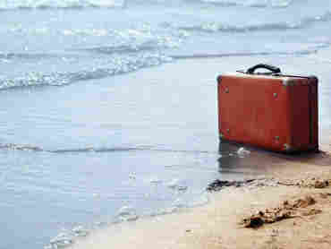Lost luggage on a beach.