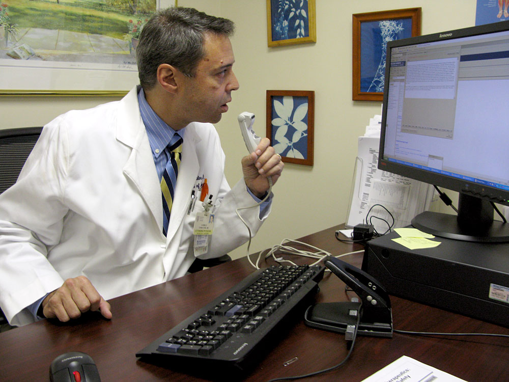 Dr. Carlo Tornatore, director of the Multiple Sclerosis Center at Georgetown University Hospital, uses a special medical version of Dragon voice recognition software to enter notes on a patient encounter.