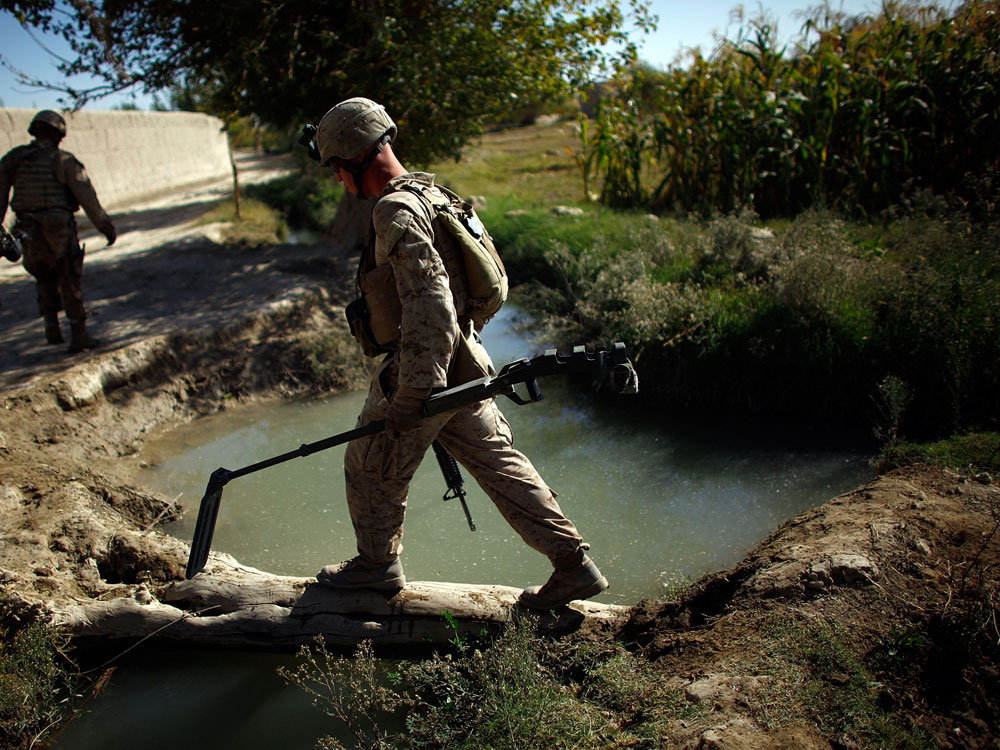 A Marine with with Fox Company of the 2nd Battalion, 8th Marine Regiment carries a metal detector at the front of his patrol in Helmand province in southern Afghanistan near Garmsir.