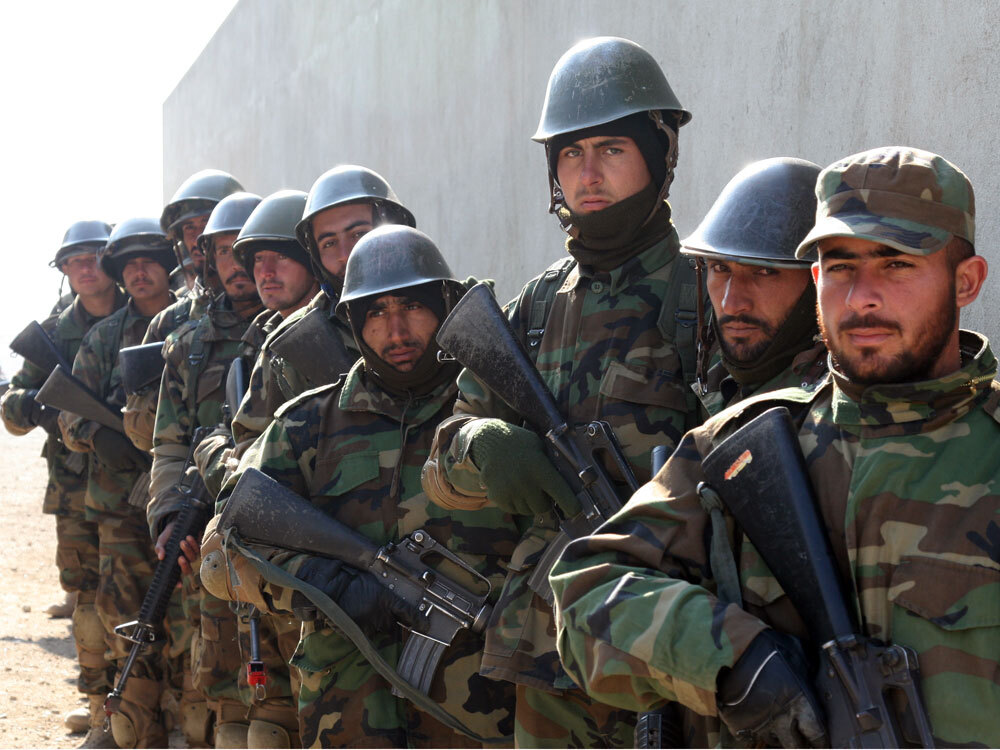 Afghan soldiers prepare to run a mock raid on a house.