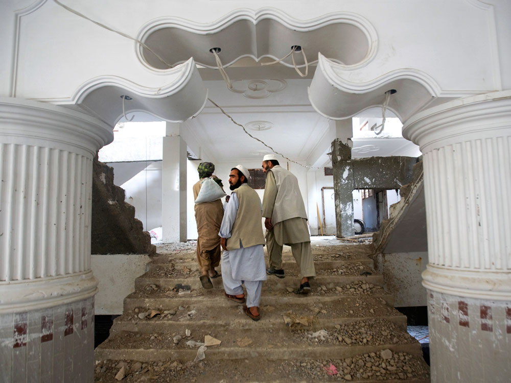 Contractors walk through an apartment complex in Afghanistan.